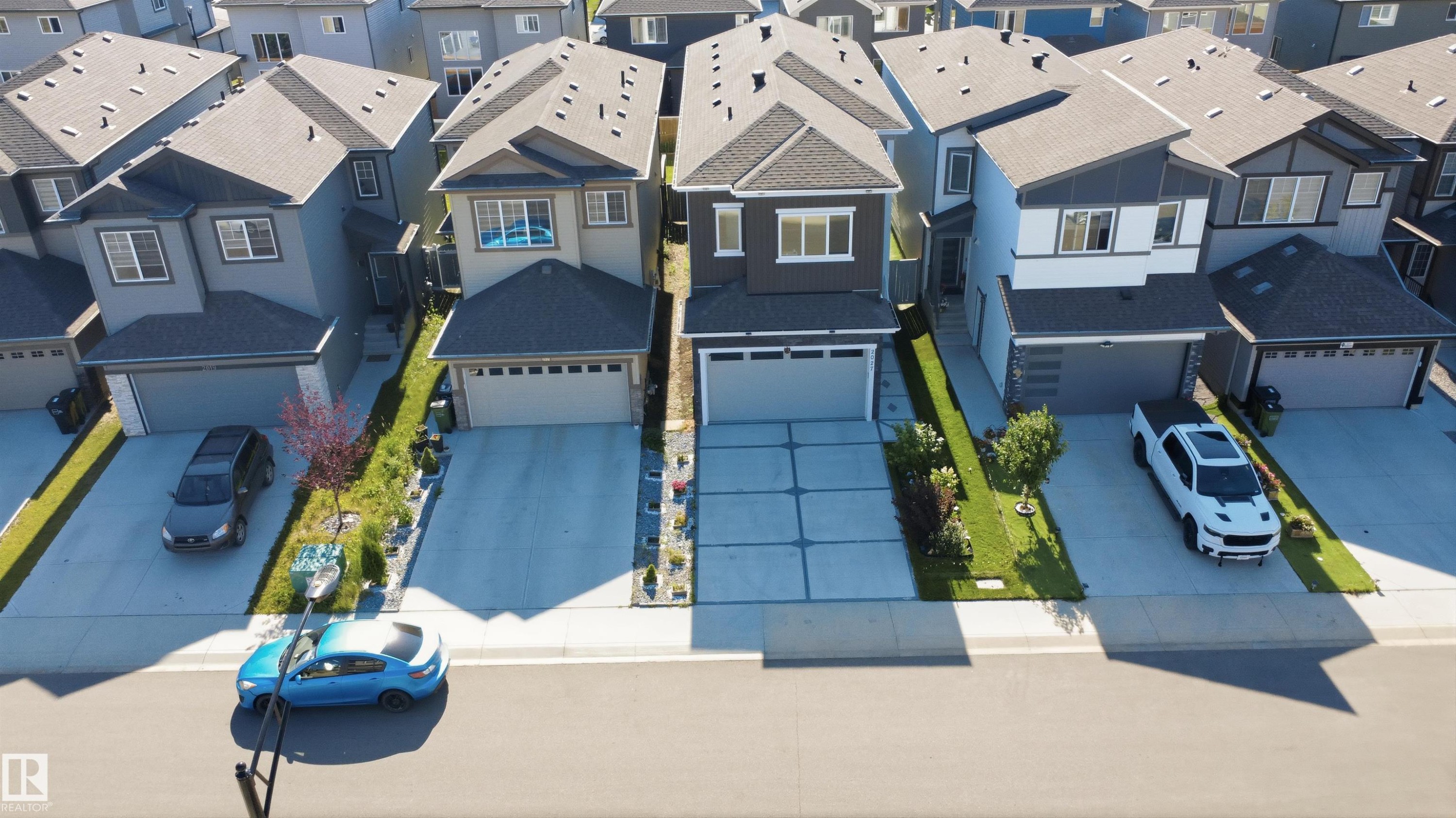 Contemporary exterior with a dark gray and white facade, integrated garage, and a concrete driveway - 2027 13 Avenue Nw, Edmonton, AB
