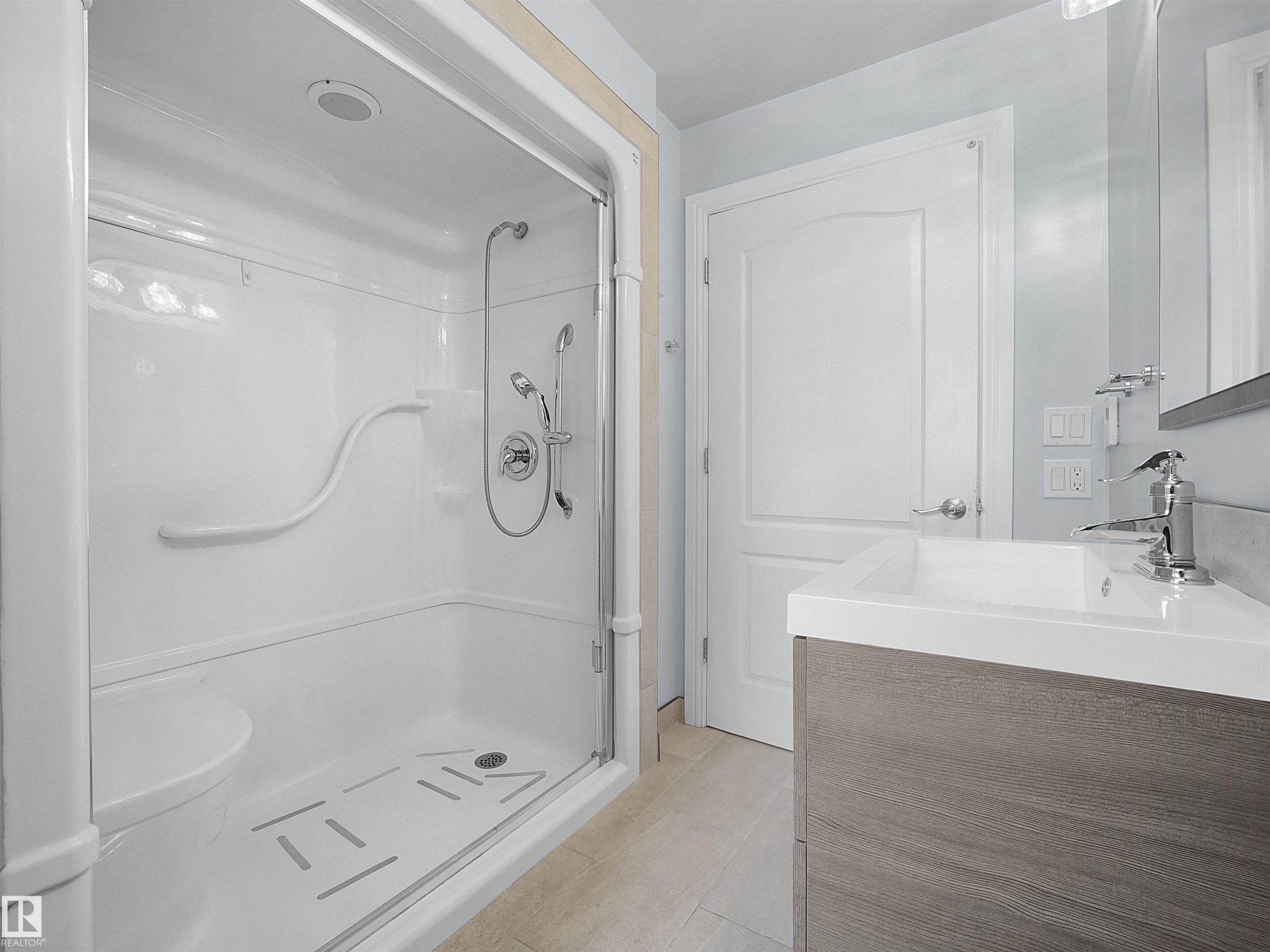 Walk-in shower with integrated seating, grab bars, and a clear glass enclosure - 7435 32 Avenue Nw, Edmonton, AB