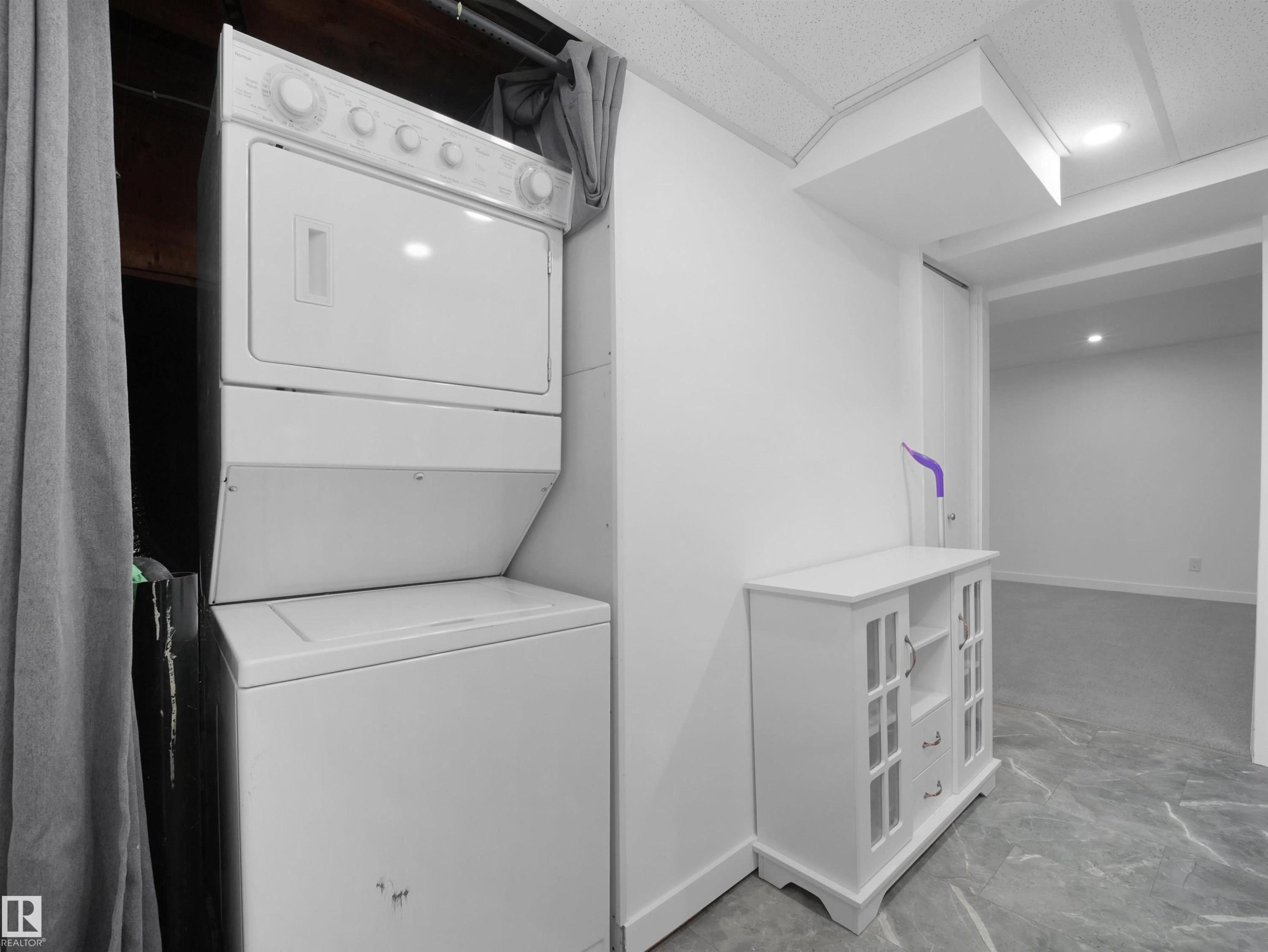 Stackable laundry appliances, drop ceiling, recessed lighting, and a durable tile-finish floor - 7435 32 Avenue Nw, Edmonton, AB