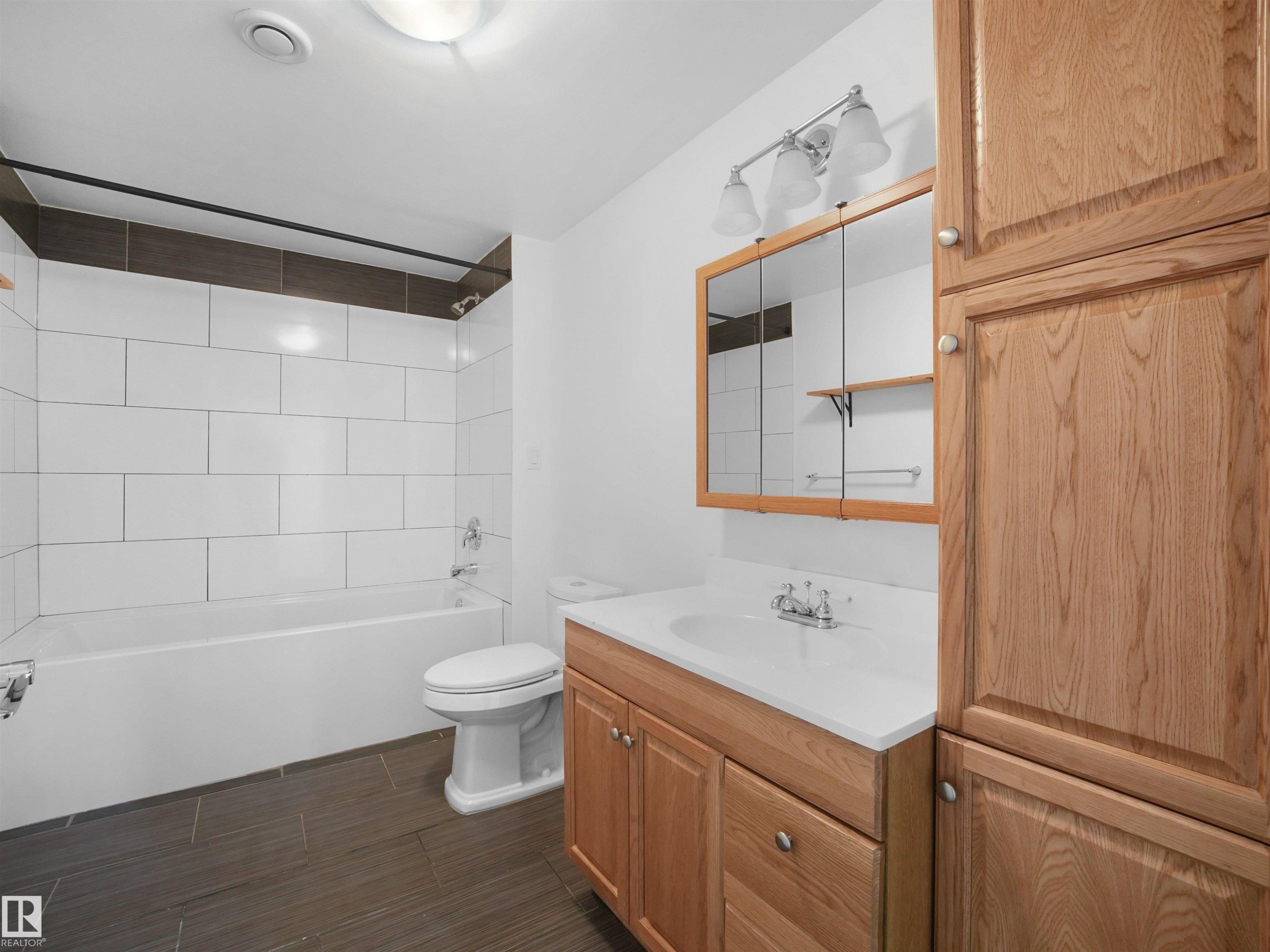White subway tile tub surround with dark accent band - 7435 32 Avenue Nw, Edmonton, AB