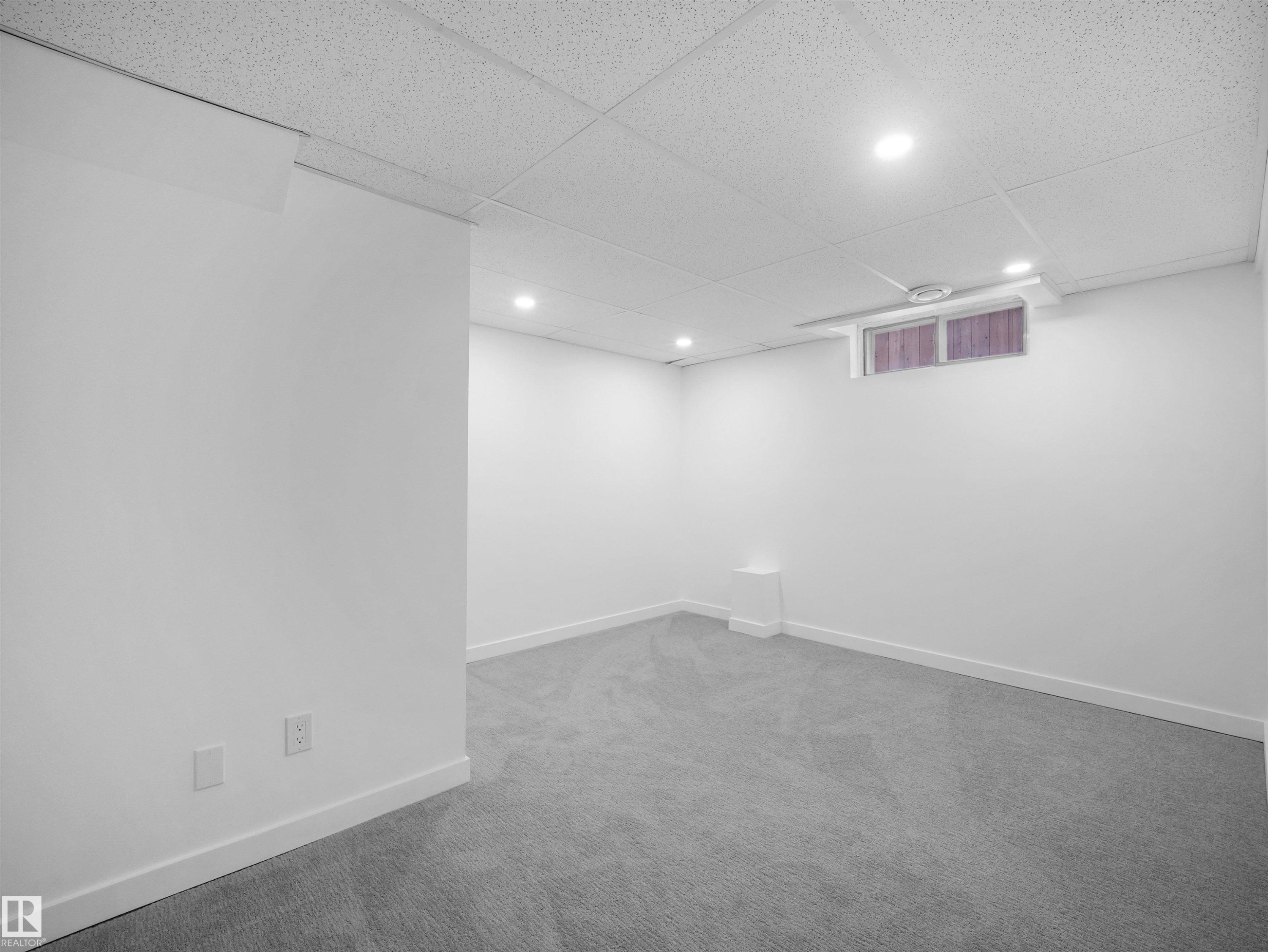 Recessed lighting illuminates this carpeted space with a drop ceiling and a window - 7435 32 Avenue Nw, Edmonton, AB
