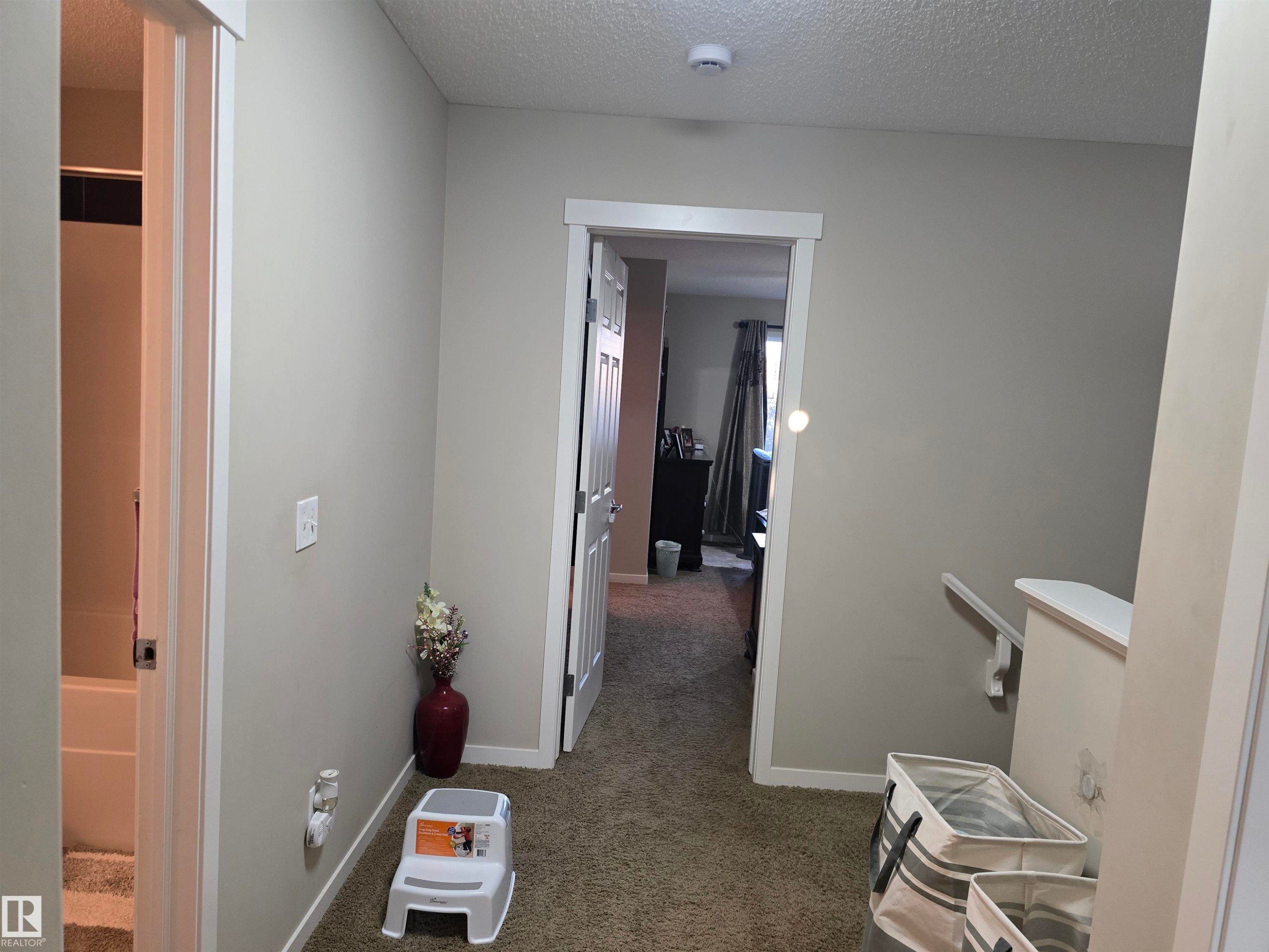 Textured carpeting and neutral wall tones - 1474 33B Street Nw, Edmonton, AB
