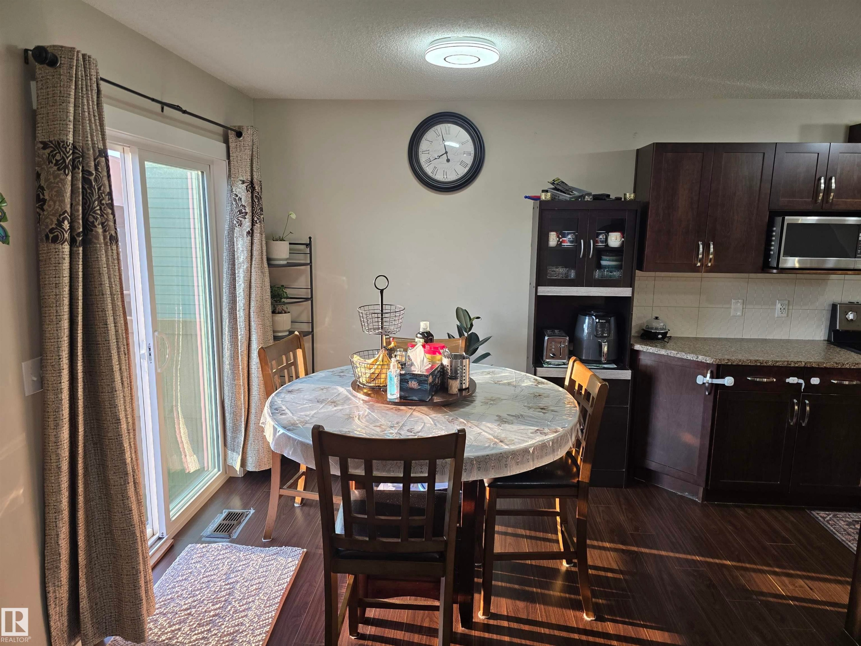 Wood-finish flooring throughout the kitchen and dining area - 1474 33B Street Nw, Edmonton, AB