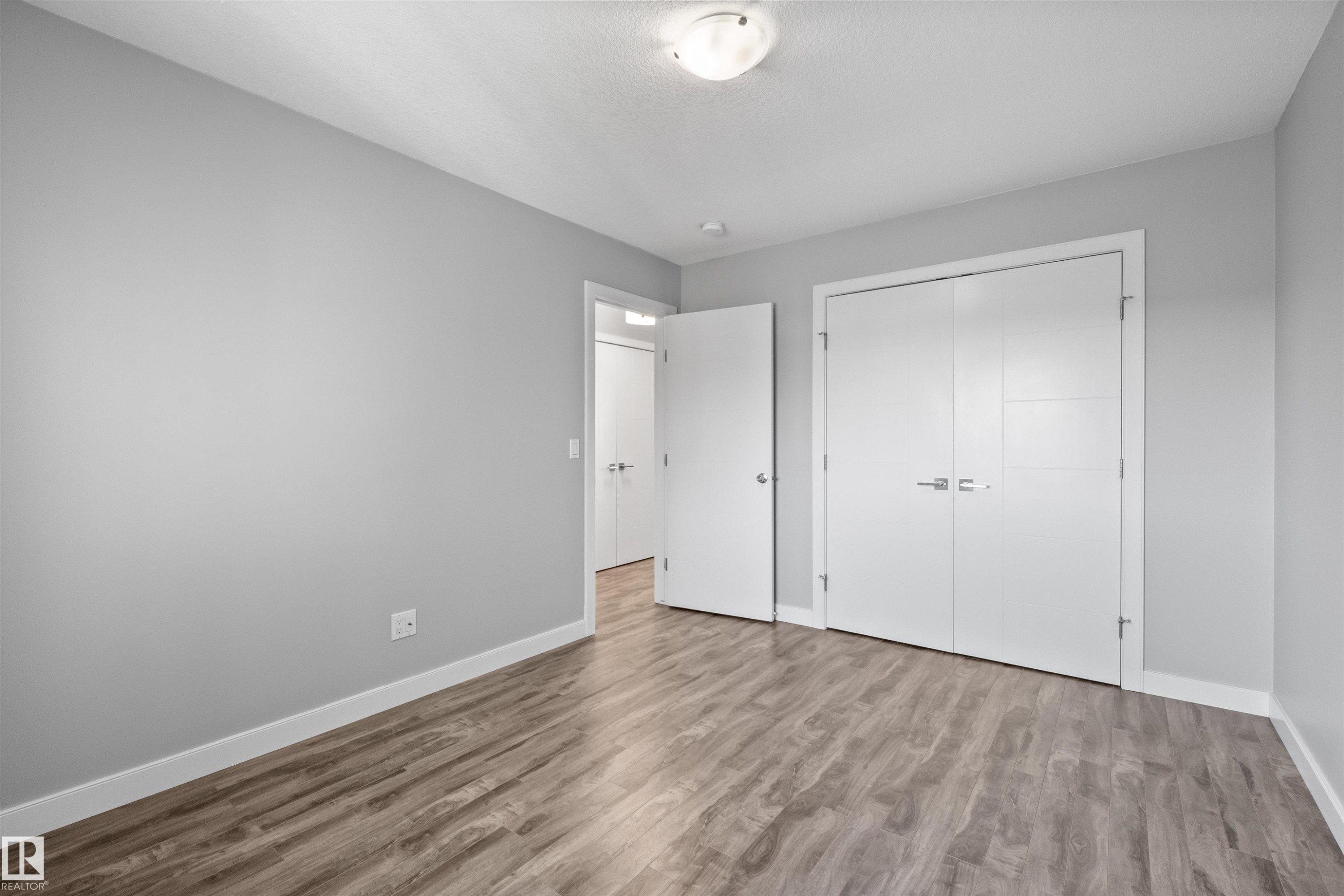 Wood-finish flooring, light gray wall paint, and white trim throughout - 2585 Pegasus Boulevard Nw, Edmonton, AB