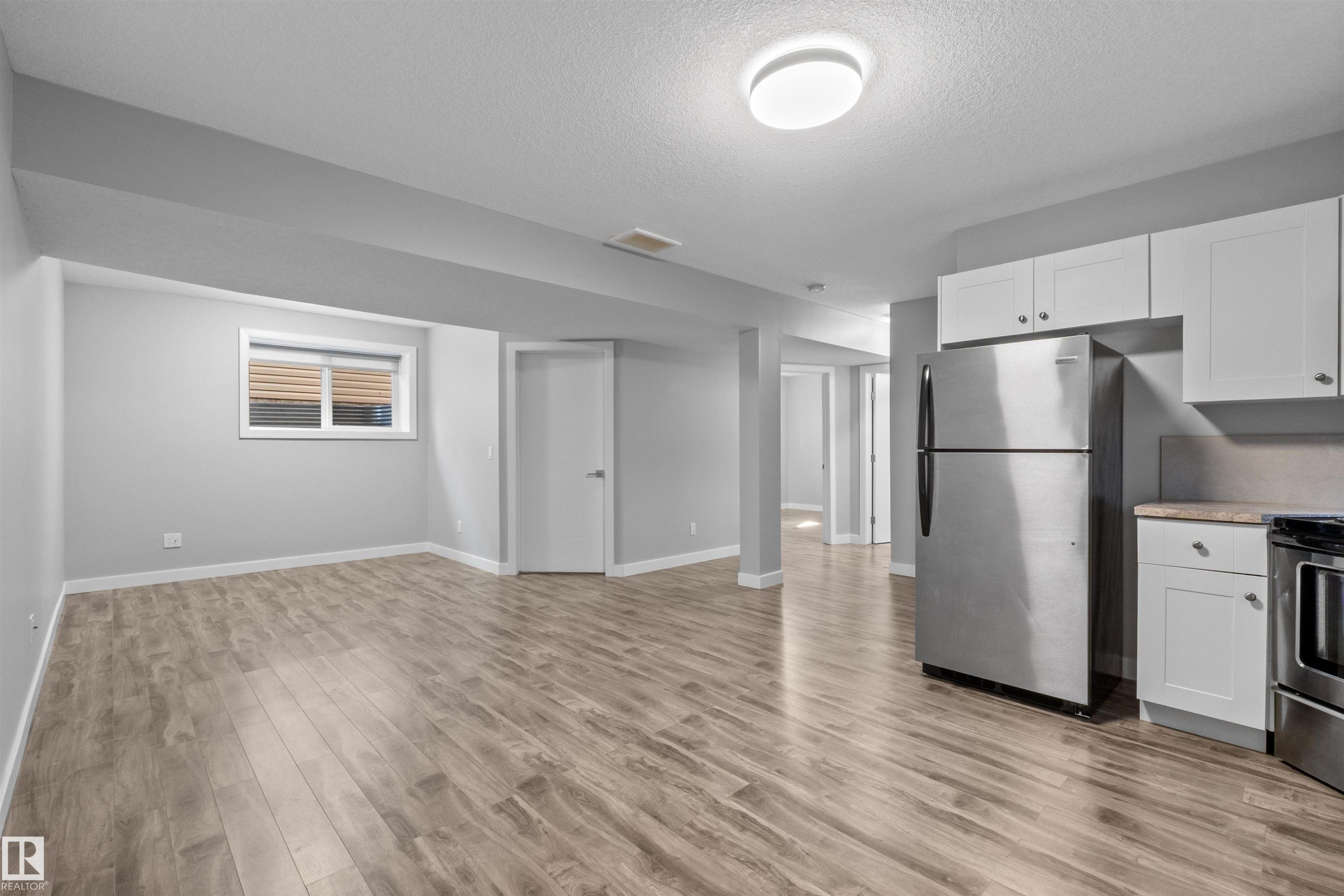 Open concept living area with wood-finish flooring, recessed lighting, and a window - 2585 Pegasus Boulevard Nw, Edmonton, AB