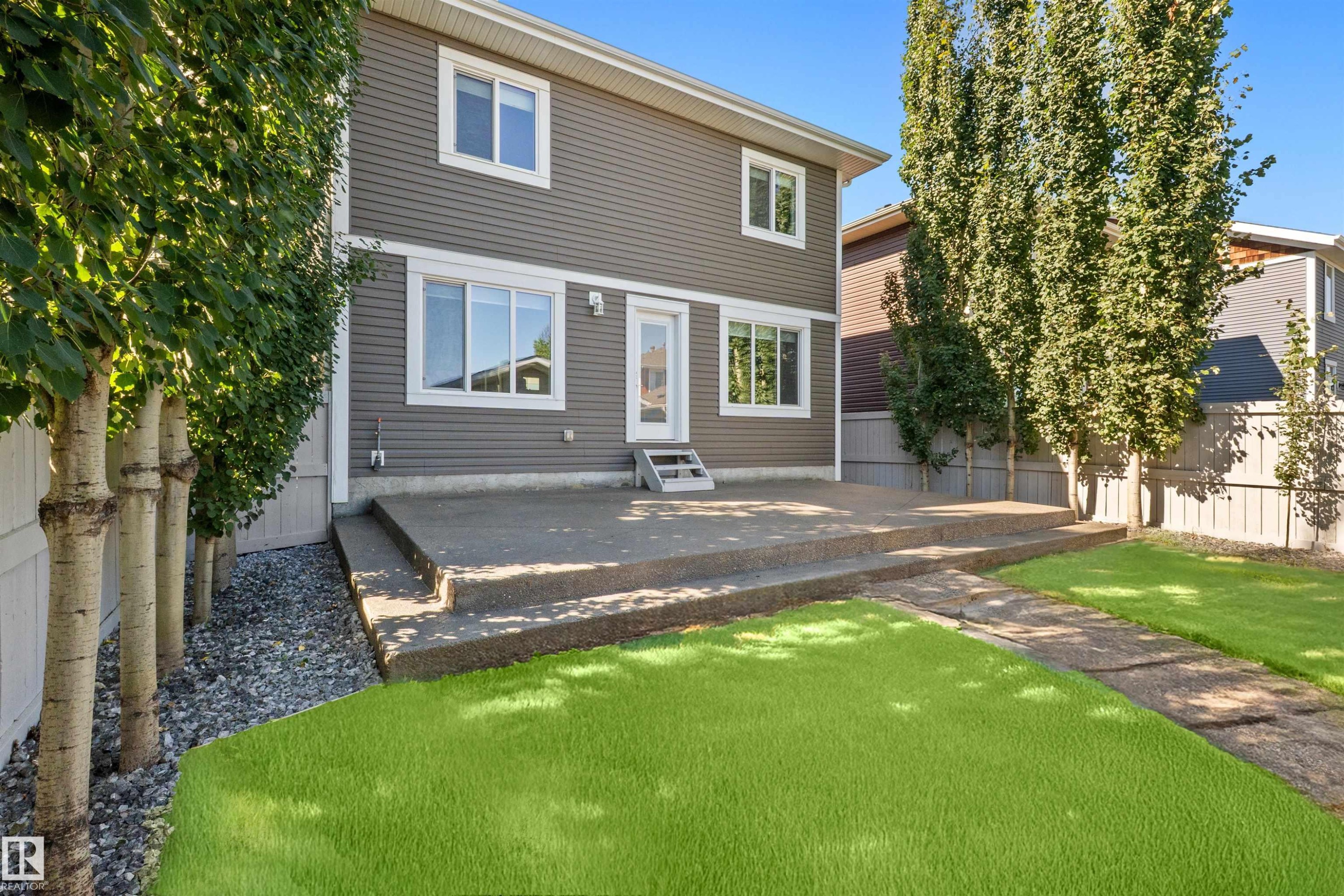 Rear exterior with gray horizontal siding and white trim - 2585 Pegasus Boulevard Nw, Edmonton, AB