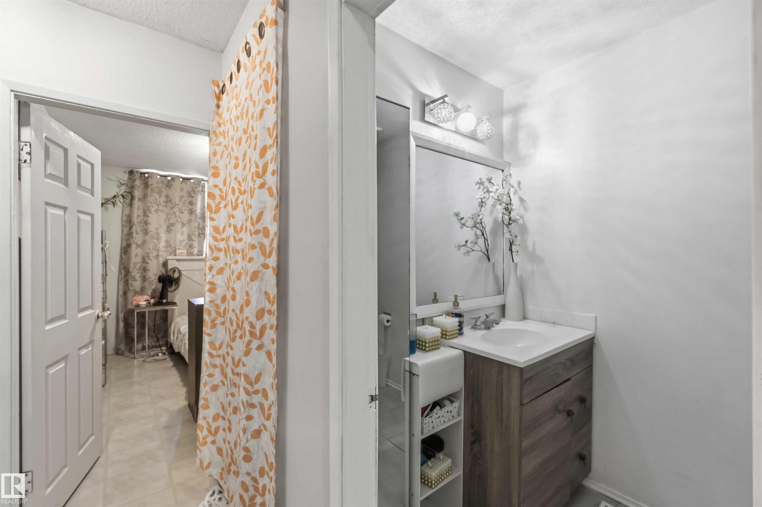Vanity with a wood-finish cabinet, white countertop, and integrated sink - 13408 67 Street Nw, Edmonton, AB