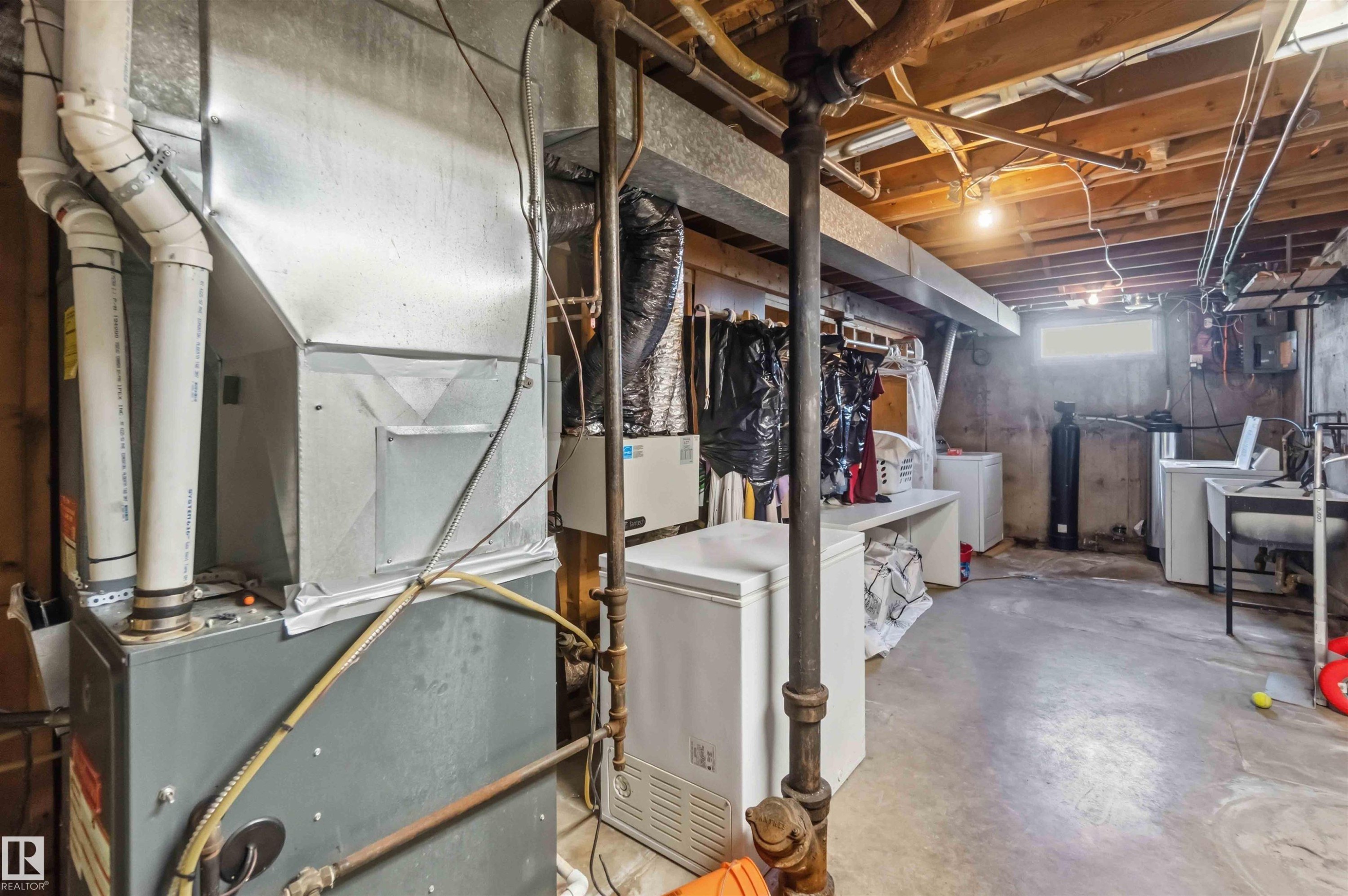 Utility room with exposed ceiling joists, concrete flooring, and an egress window - 13408 67 Street Nw, Edmonton, AB