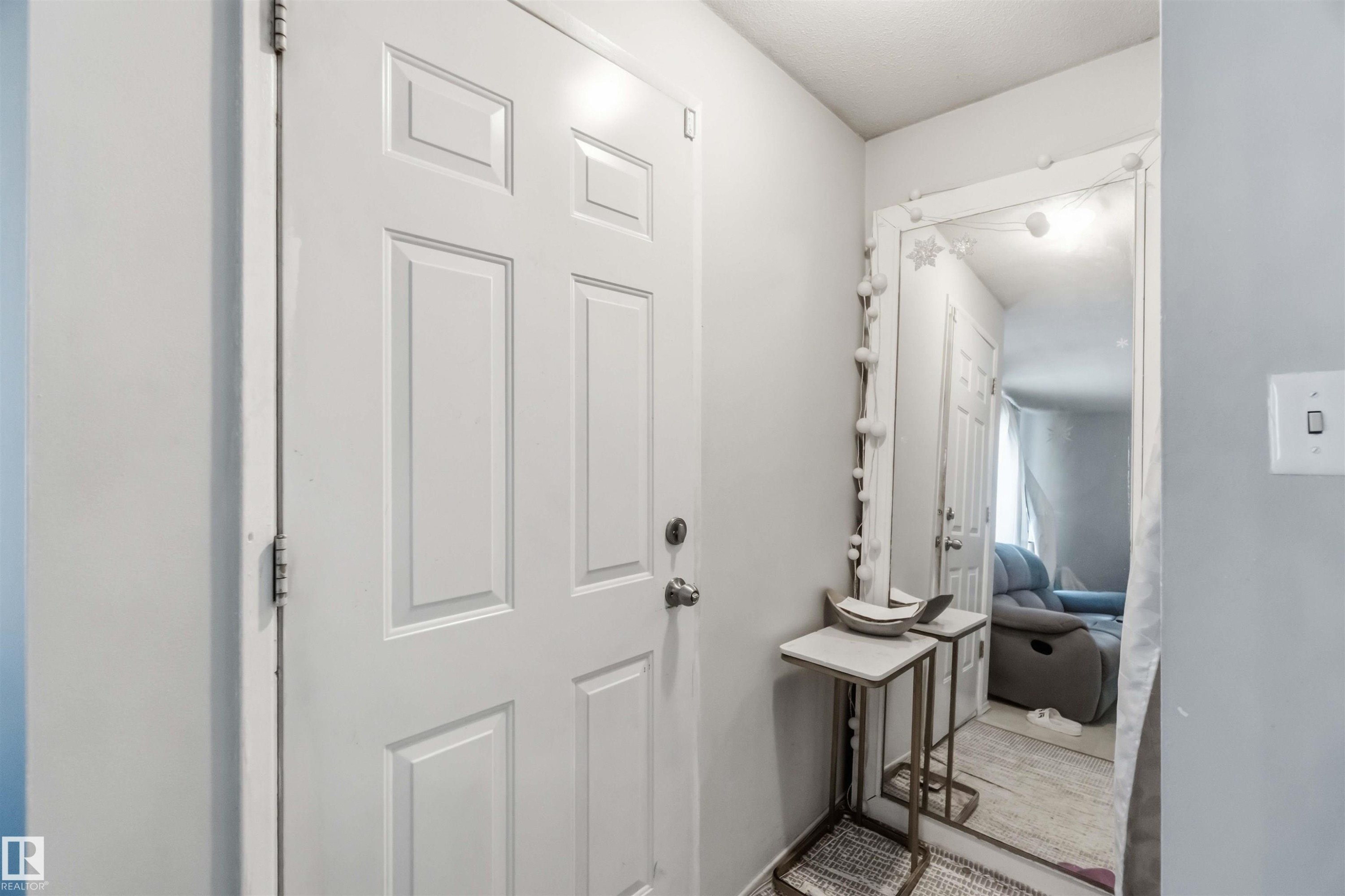 White paneled entry door with round knob, light gray wall, and white trim - 13408 67 Street Nw, Edmonton, AB