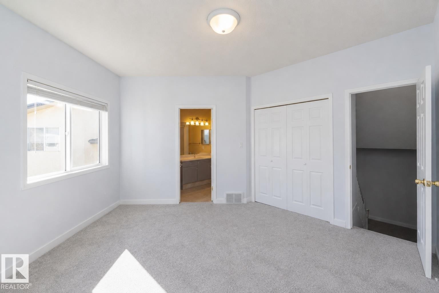 Light-colored wall-to-wall carpeting, white walls, double-pane window, bi-fold closet doors, and recessed ceiling light fixture - #37 3811 85 St Nw, Edmonton, AB