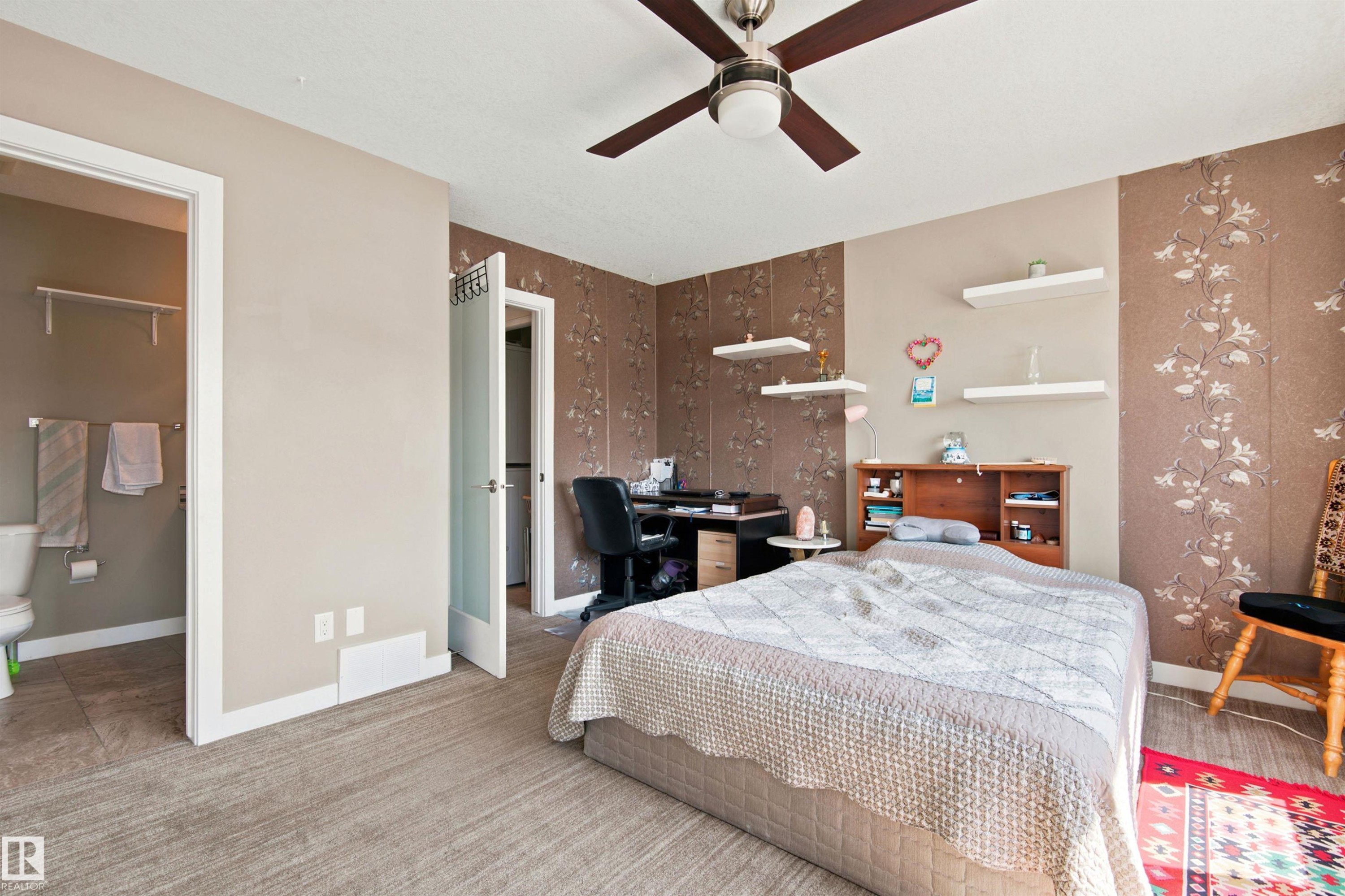 Ceiling fan with integrated lighting, wood-finish flooring, accent wall with decorative wall covering, built-in shelving, and frosted glass interior door - 10833 63 Avenue Nw, Edmonton, AB