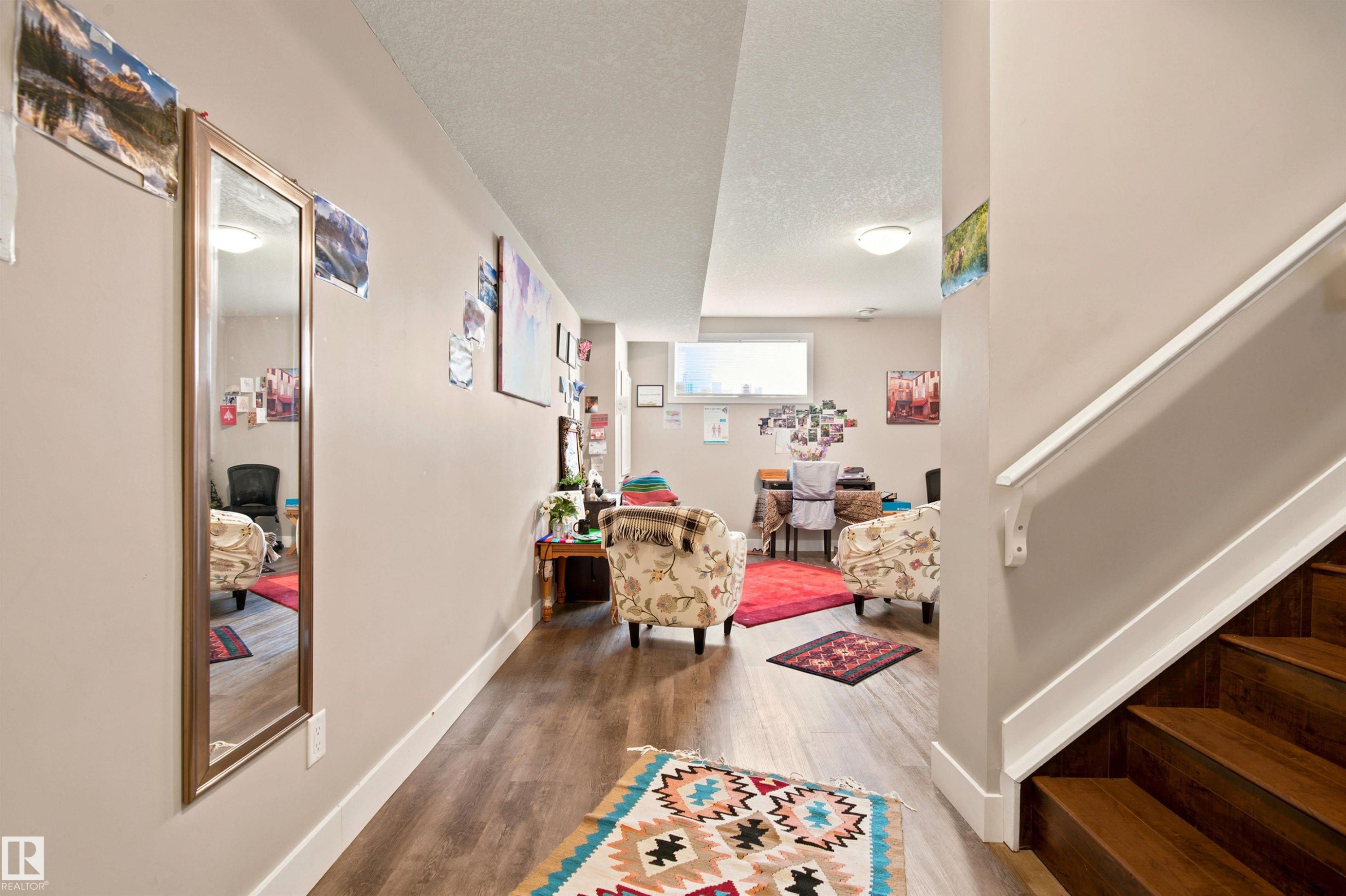 Wood-finish flooring, white trim, and a horizontal window - 10833 63 Avenue Nw, Edmonton, AB