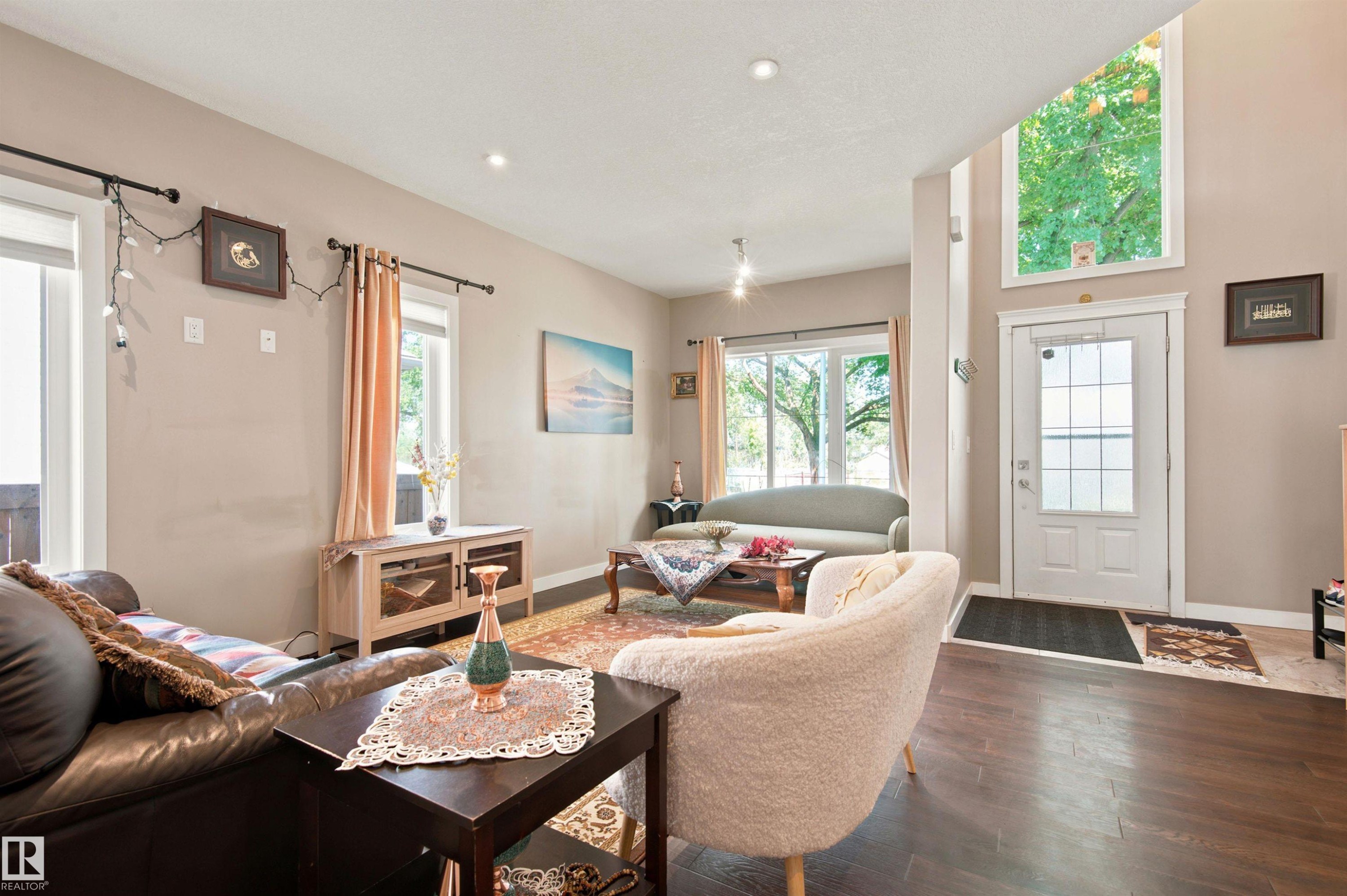 Rich wood-finish flooring, recessed lighting, and a white paneled door with decorative glass - 10833 63 Avenue Nw, Edmonton, AB