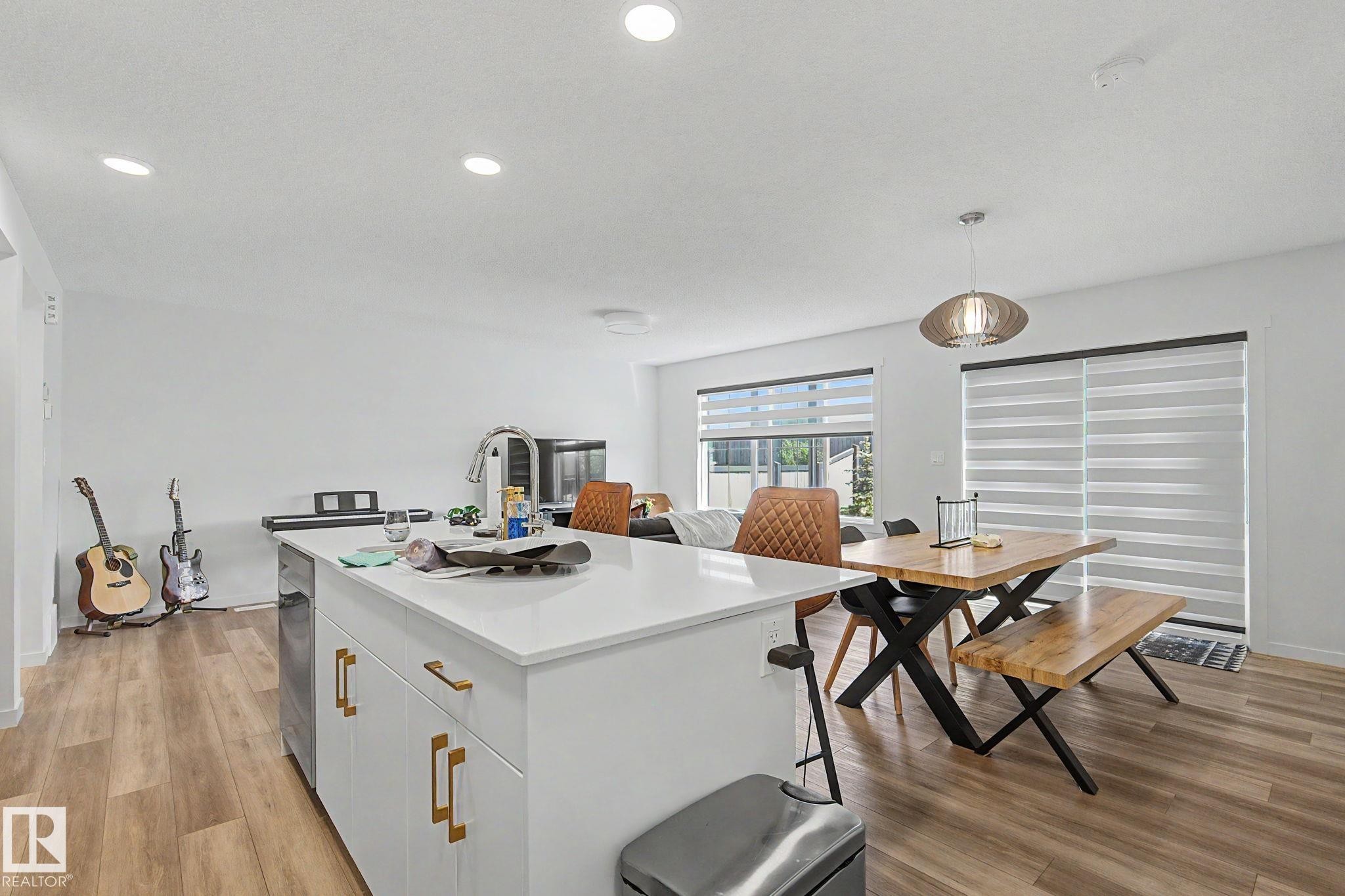 Open-concept living space featuring wood-finish flooring, recessed lighting, and white walls - #12 905 172 St Sw, Edmonton, AB - Indoor