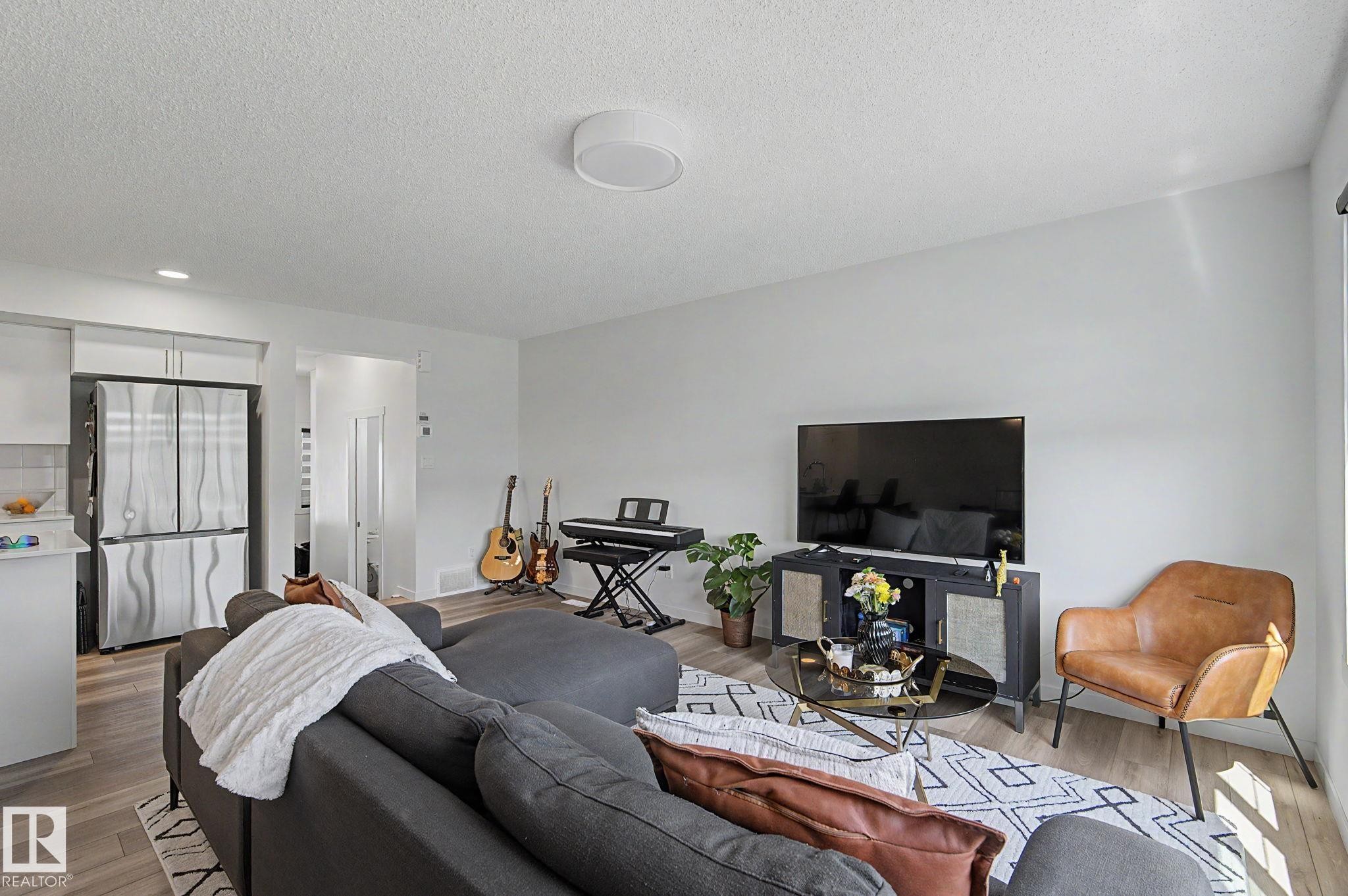 Open concept living space featuring light wood-finish flooring and light-toned walls - #12 905 172 St Sw, Edmonton, AB - Indoor Photo Showing Living Room