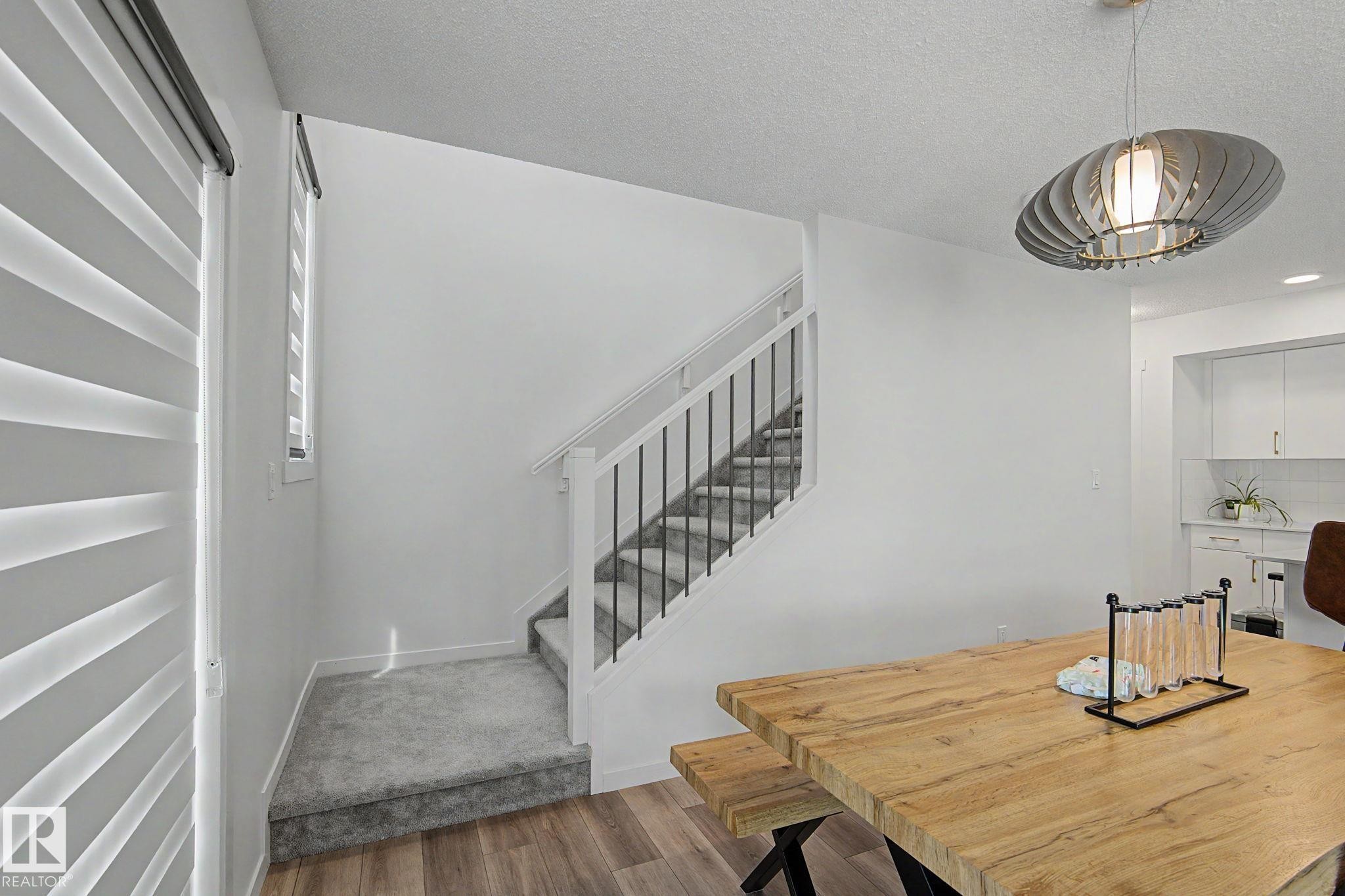 Staircase featuring white risers, carpeted treads, and iron balusters - #12 905 172 St Sw, Edmonton, AB - Indoor Photo Showing Other Room
