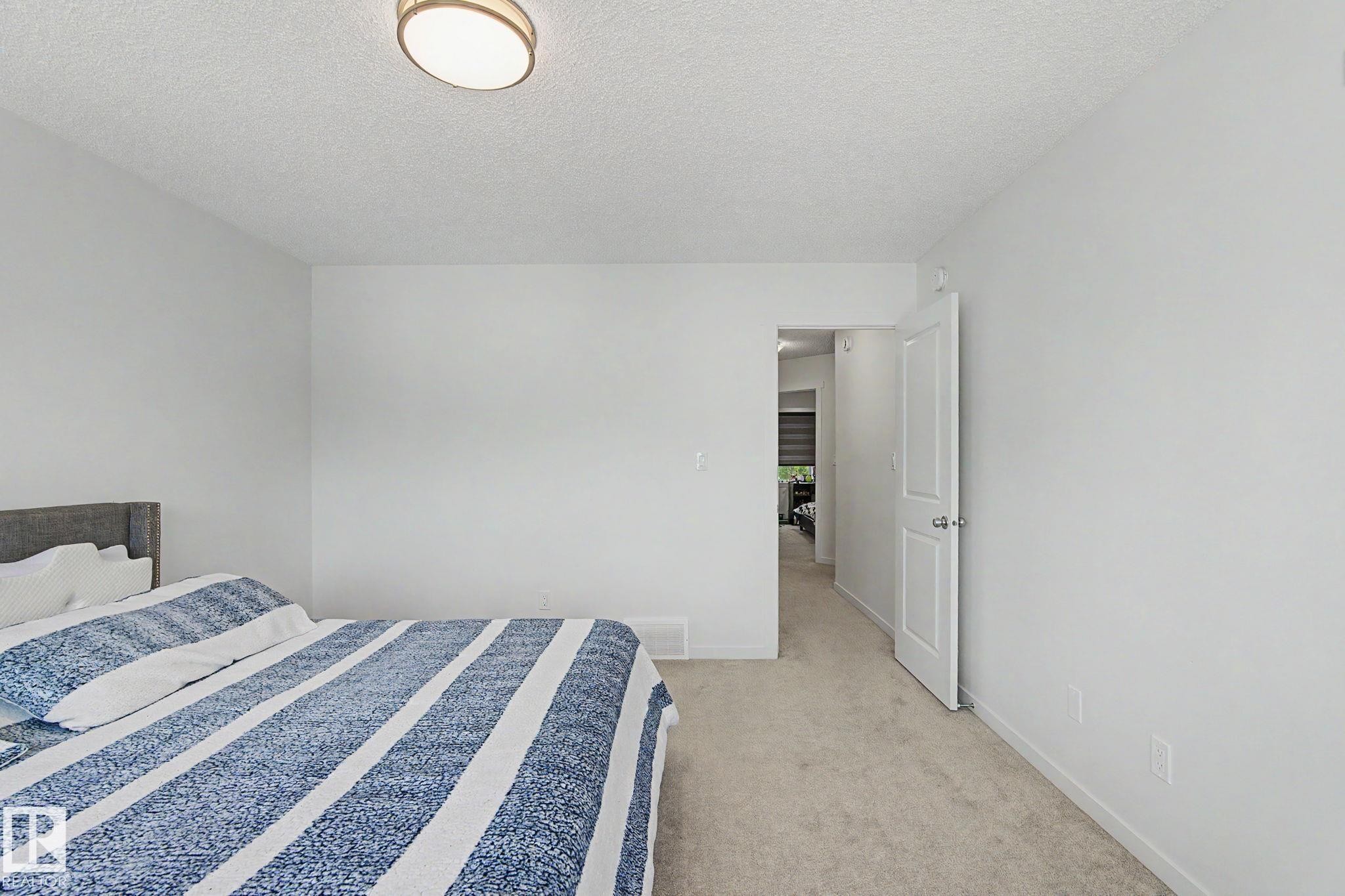 Light-filled room featuring neutral wall finishes and plush carpet flooring - #12 905 172 St Sw, Edmonton, AB - Indoor Photo Showing Bedroom