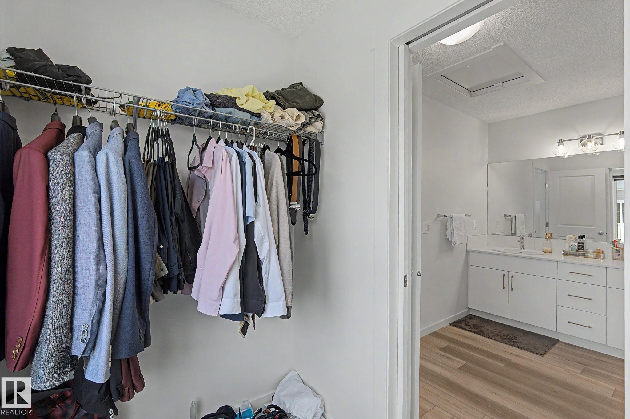 Built-in closet shelving system with metal hanging rods for vertical storage - #12 905 172 St Sw, Edmonton, AB - Indoor With Storage