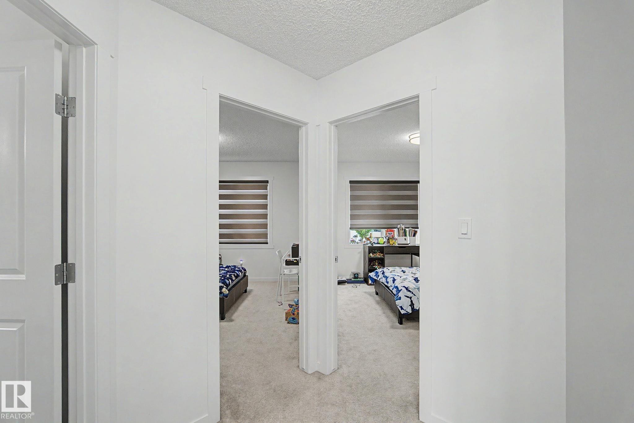 Hallway with white walls and light-toned carpeted flooring - #12 905 172 St Sw, Edmonton, AB - Indoor Photo Showing Other Room