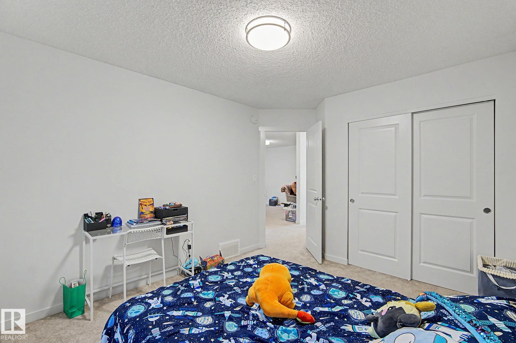 Neutral wall finishes with a textured ceiling - #12 905 172 St Sw, Edmonton, AB - Indoor Photo Showing Bedroom