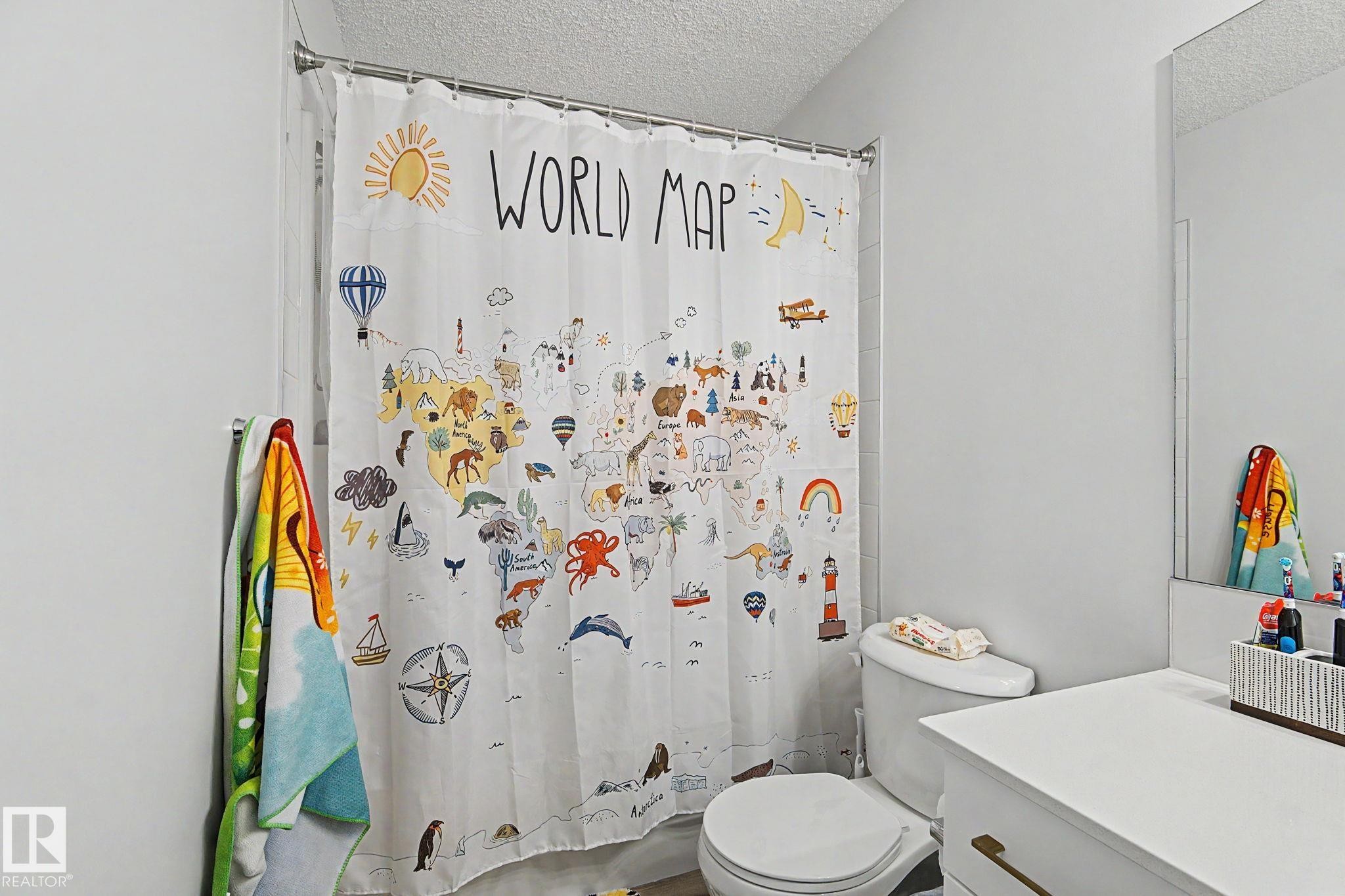 Bathroom featuring a white toilet, single vanity with white countertop, and a wall-mounted mirror - #12 905 172 St Sw, Edmonton, AB - Indoor Photo Showing Bathroom