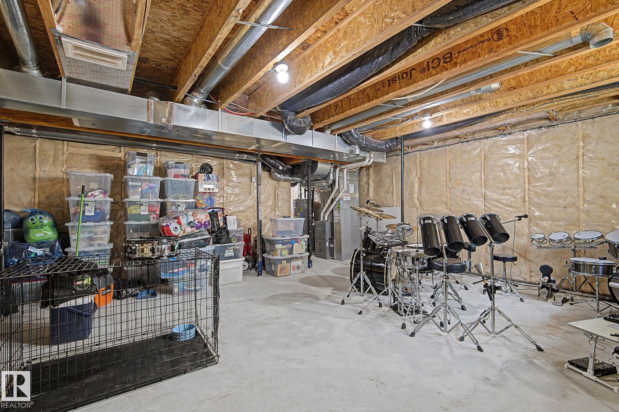 Unfinished basement with exposed ceiling joists and ductwork, concrete flooring, and insulated walls - #12 905 172 St Sw, Edmonton, AB - Indoor Photo Showing Basement