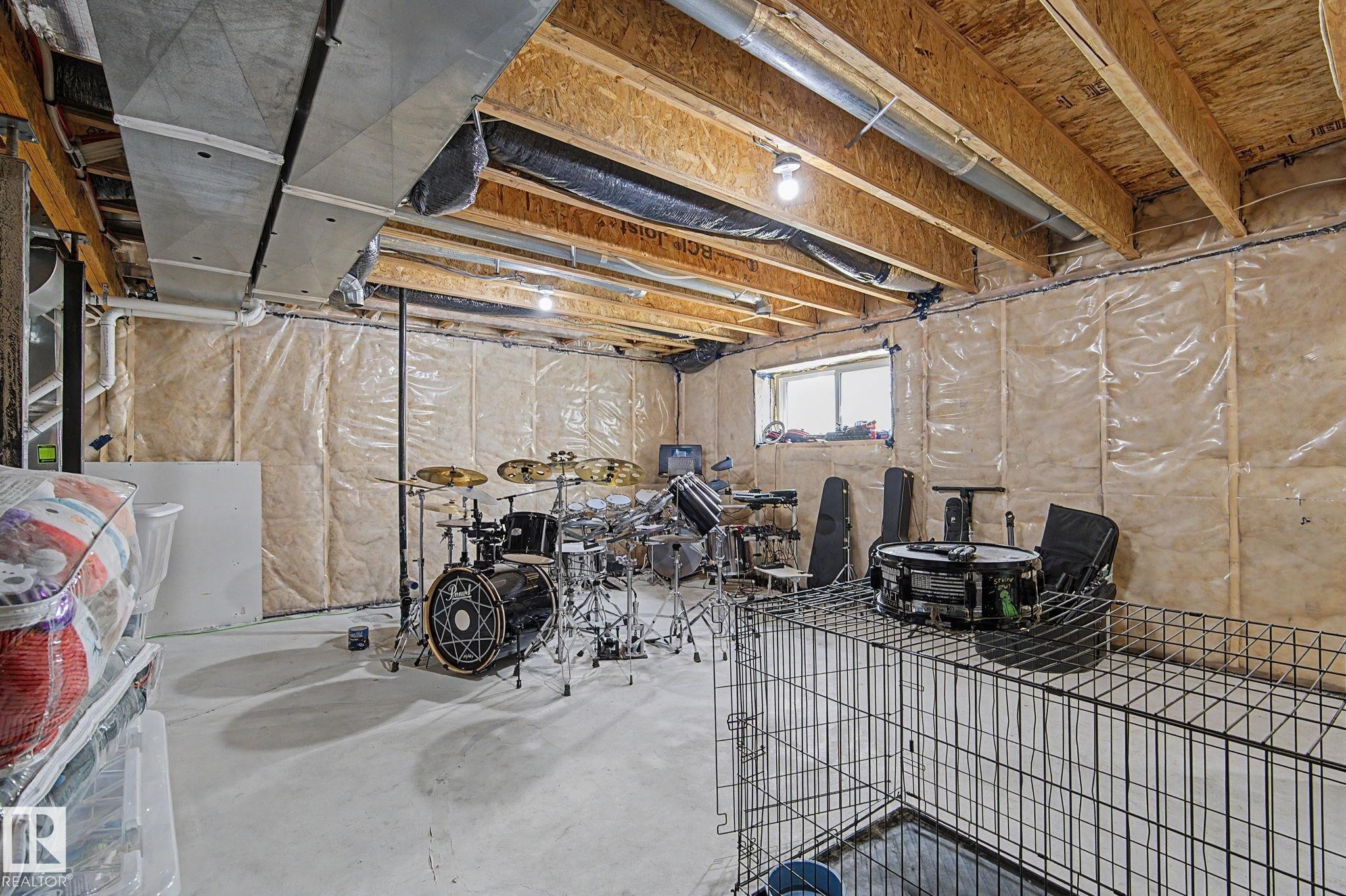 Unfinished lower level featuring an exposed wood ceiling, concrete flooring, and insulated walls - #12 905 172 St Sw, Edmonton, AB - Indoor Photo Showing Basement