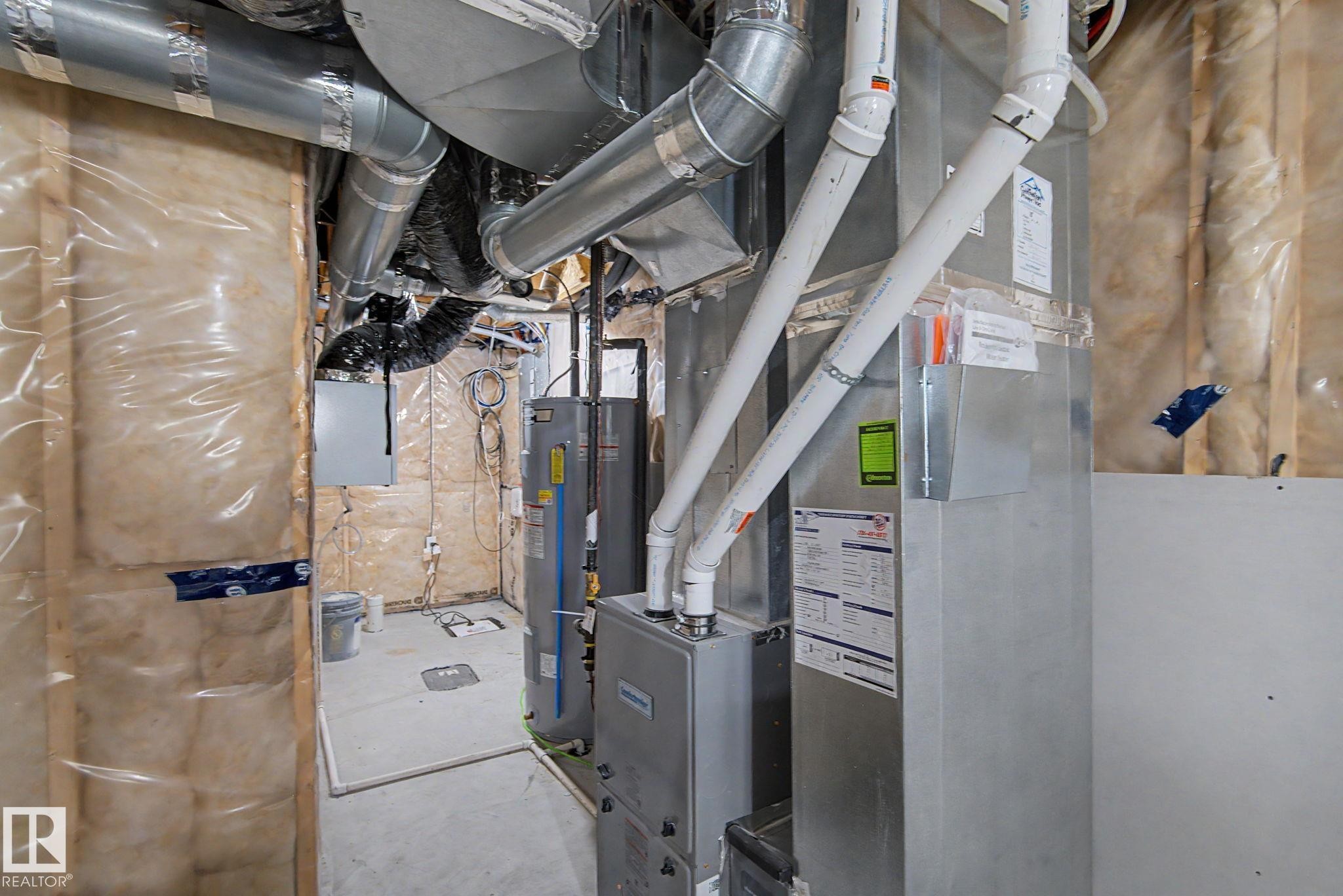 Utility room featuring a water heater, furnace, and extensive ductwork - #12 905 172 St Sw, Edmonton, AB - Indoor Photo Showing Basement