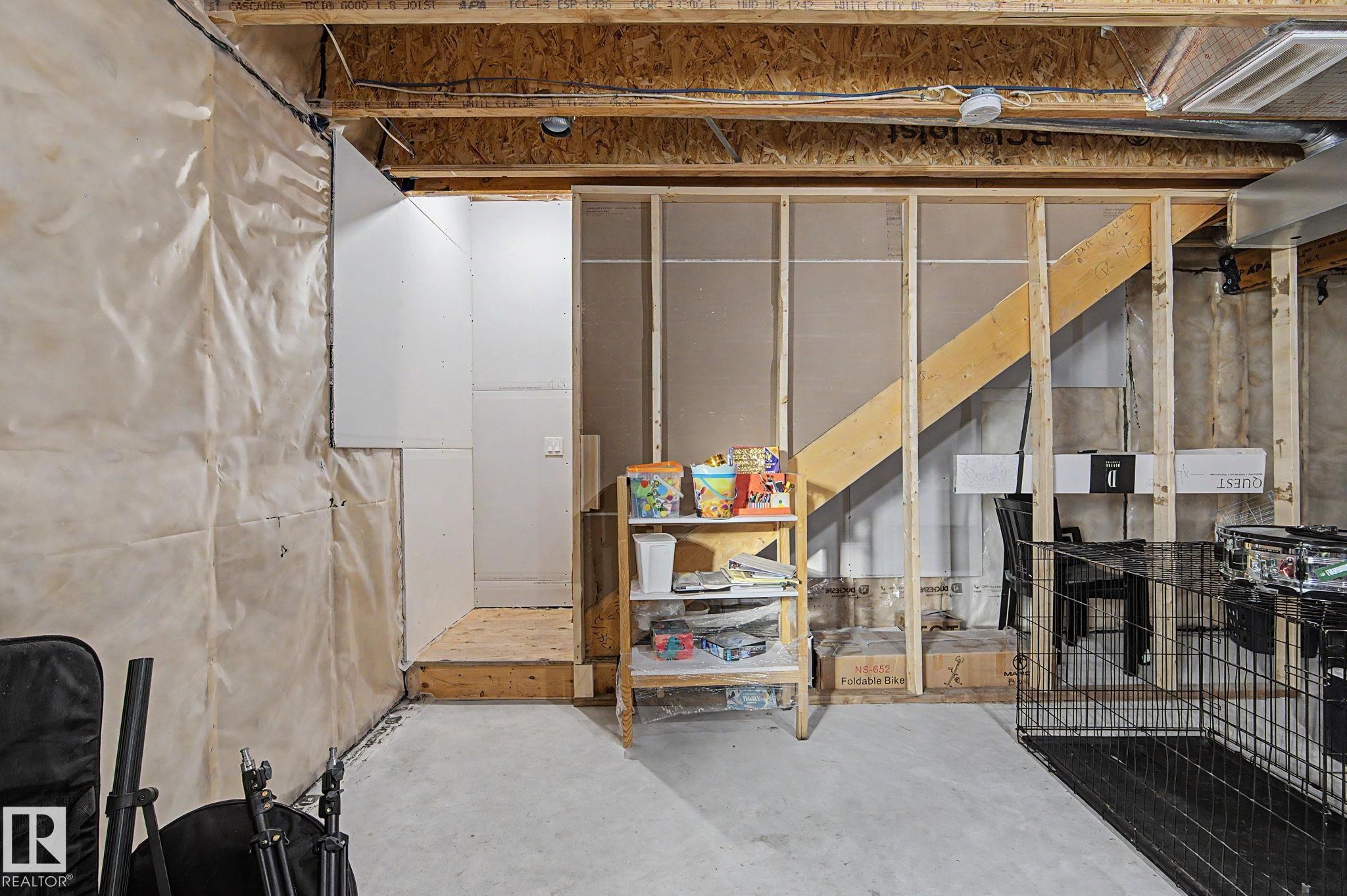 Unfinished basement space featuring exposed wooden ceiling joists, concrete flooring, and partial wall framing for future development - #12 905 172 St Sw, Edmonton, AB - Indoor Photo Showing Basement