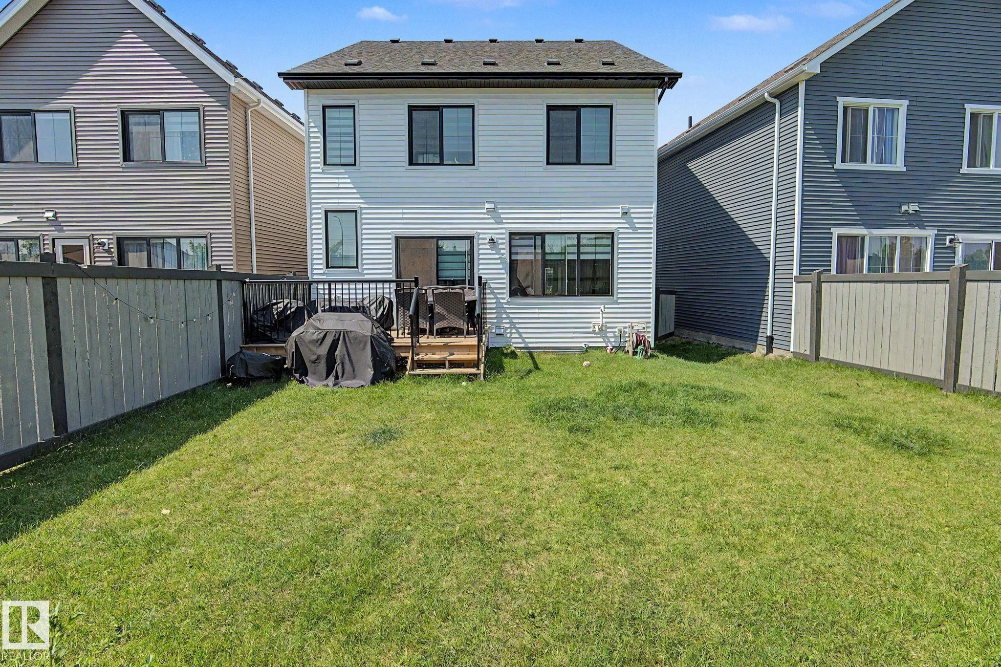 White siding exterior with multiple windows featuring dark trim - #12 905 172 St Sw, Edmonton, AB - Outdoor With Exterior