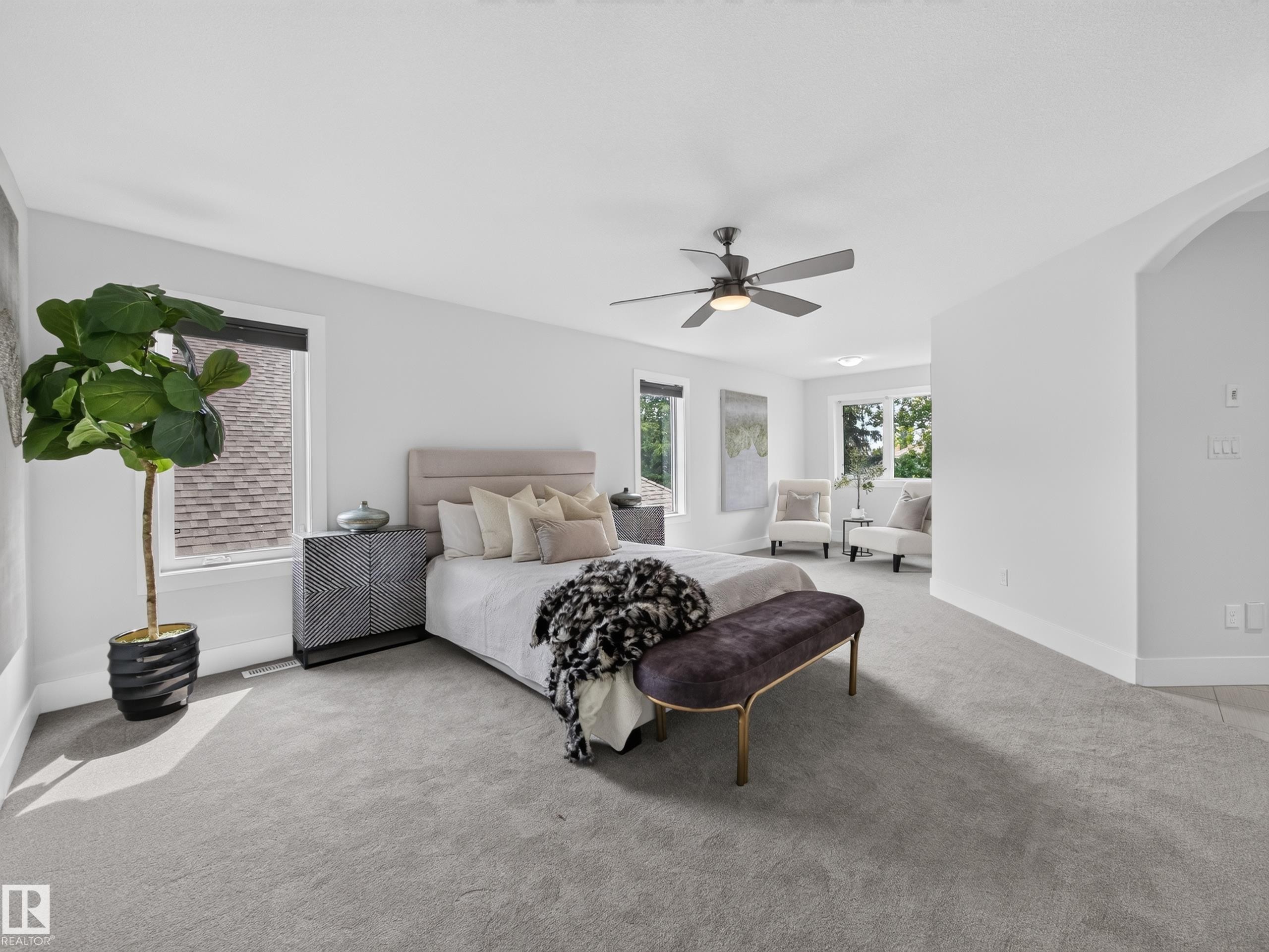 Spacious bedroom with light gray carpeting, multiple windows, and a ceiling fan - #59 10550 Ellerslie Rd Sw, Edmonton, AB - Indoor Photo Showing Bedroom