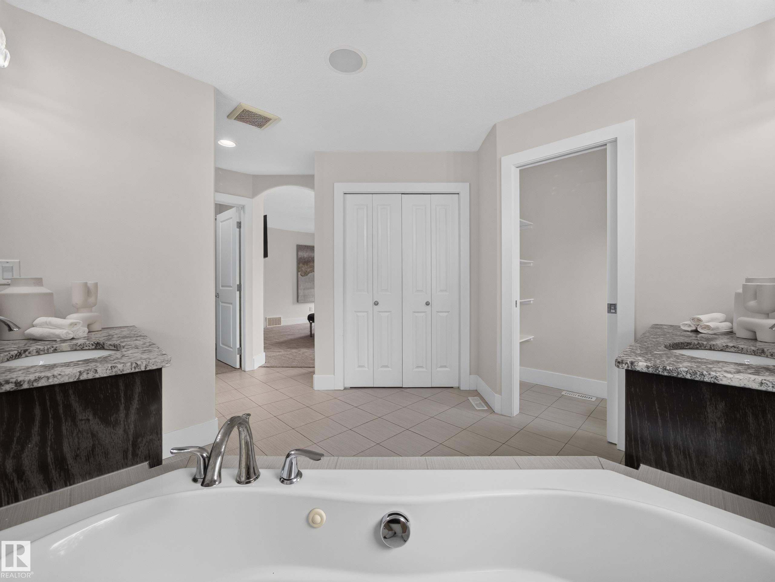White soaking tub with polished chrome fixtures - #59 10550 Ellerslie Rd Sw, Edmonton, AB - Indoor Photo Showing Bathroom