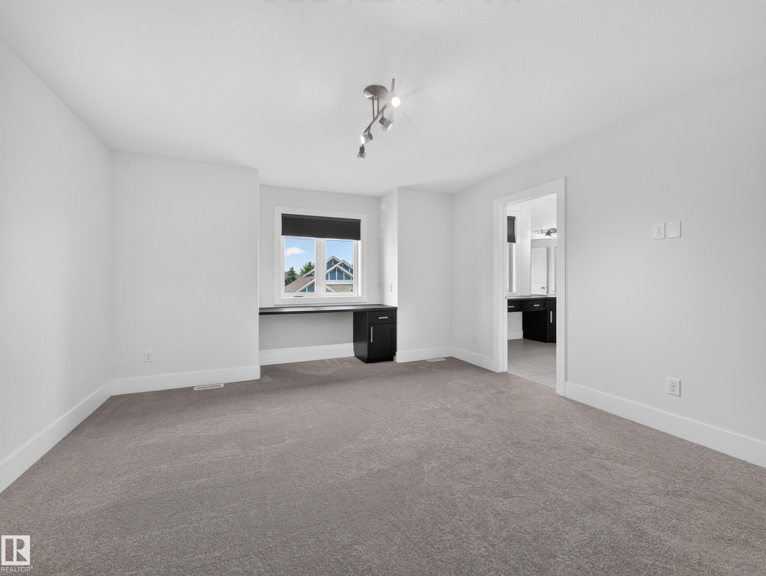 Neutral tone carpeting complementing crisp white walls and baseboards - #59 10550 Ellerslie Rd Sw, Edmonton, AB - Indoor Photo Showing Other Room