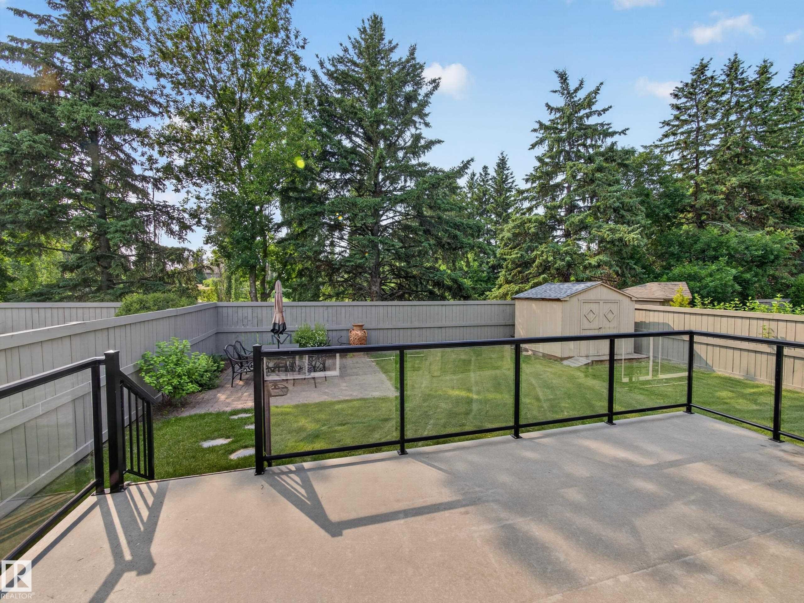 Spacious concrete patio with black aluminum and glass railing - #59 10550 Ellerslie Rd Sw, Edmonton, AB - Outdoor