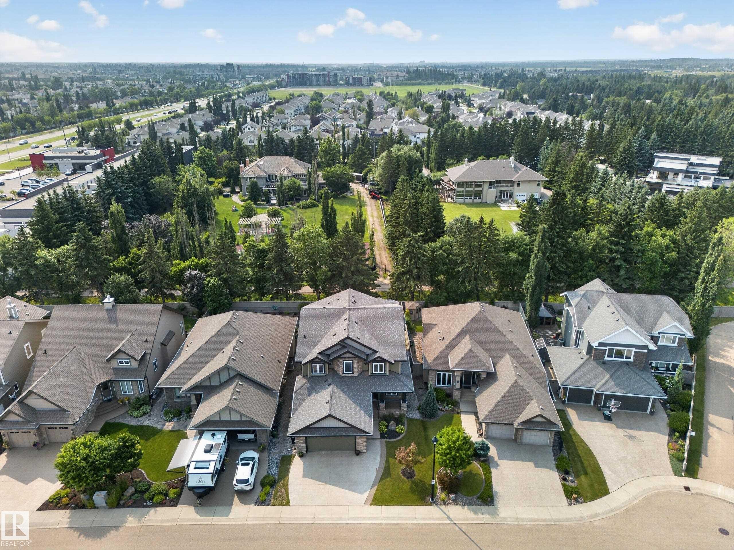 Residential area featuring mature trees and multiple detached homes - #59 10550 Ellerslie Rd Sw, Edmonton, AB - Outdoor With View