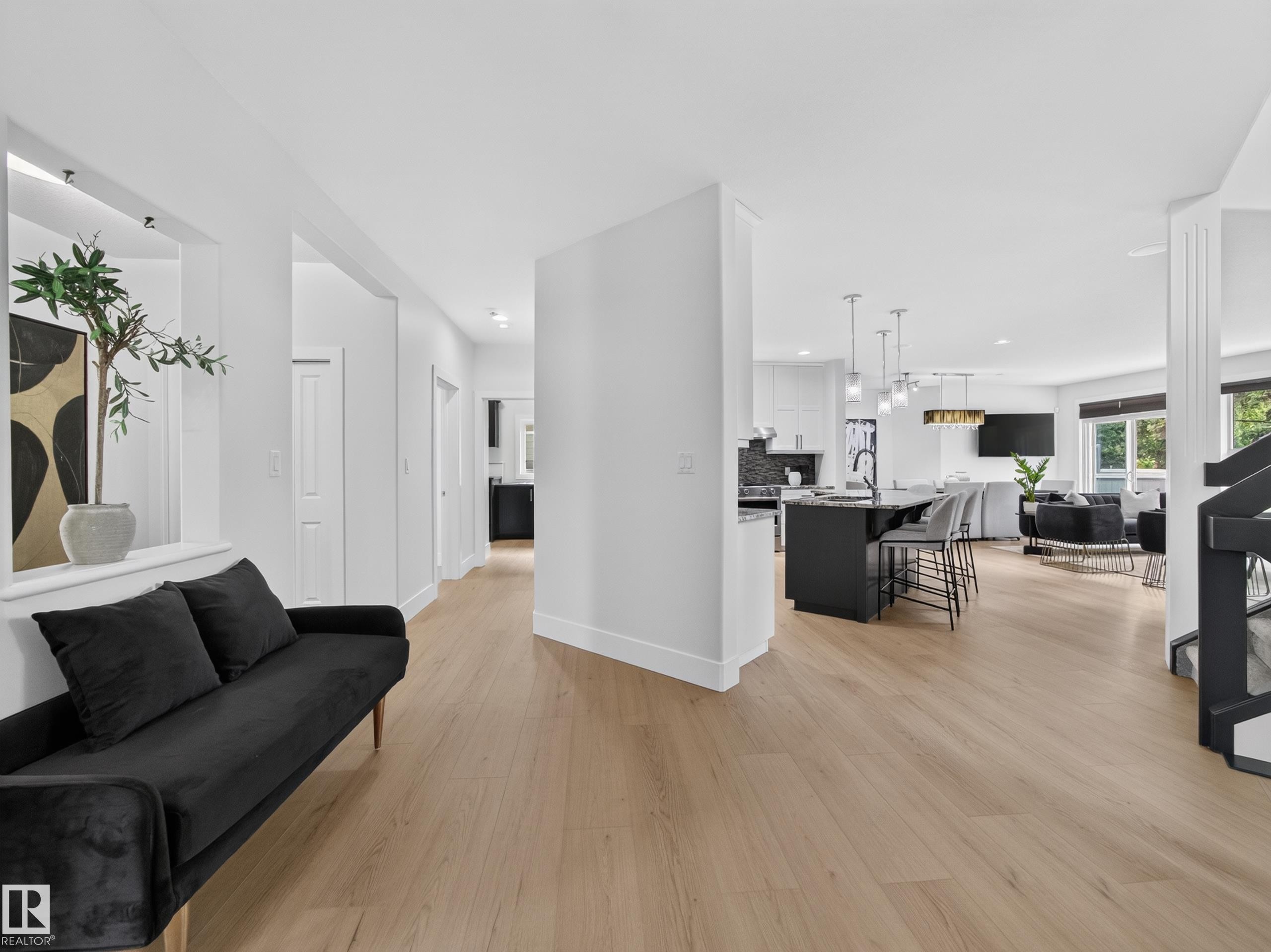 Light wood-finish flooring extends throughout this open-concept interior - #59 10550 Ellerslie Rd Sw, Edmonton, AB - Indoor Photo Showing Other Room