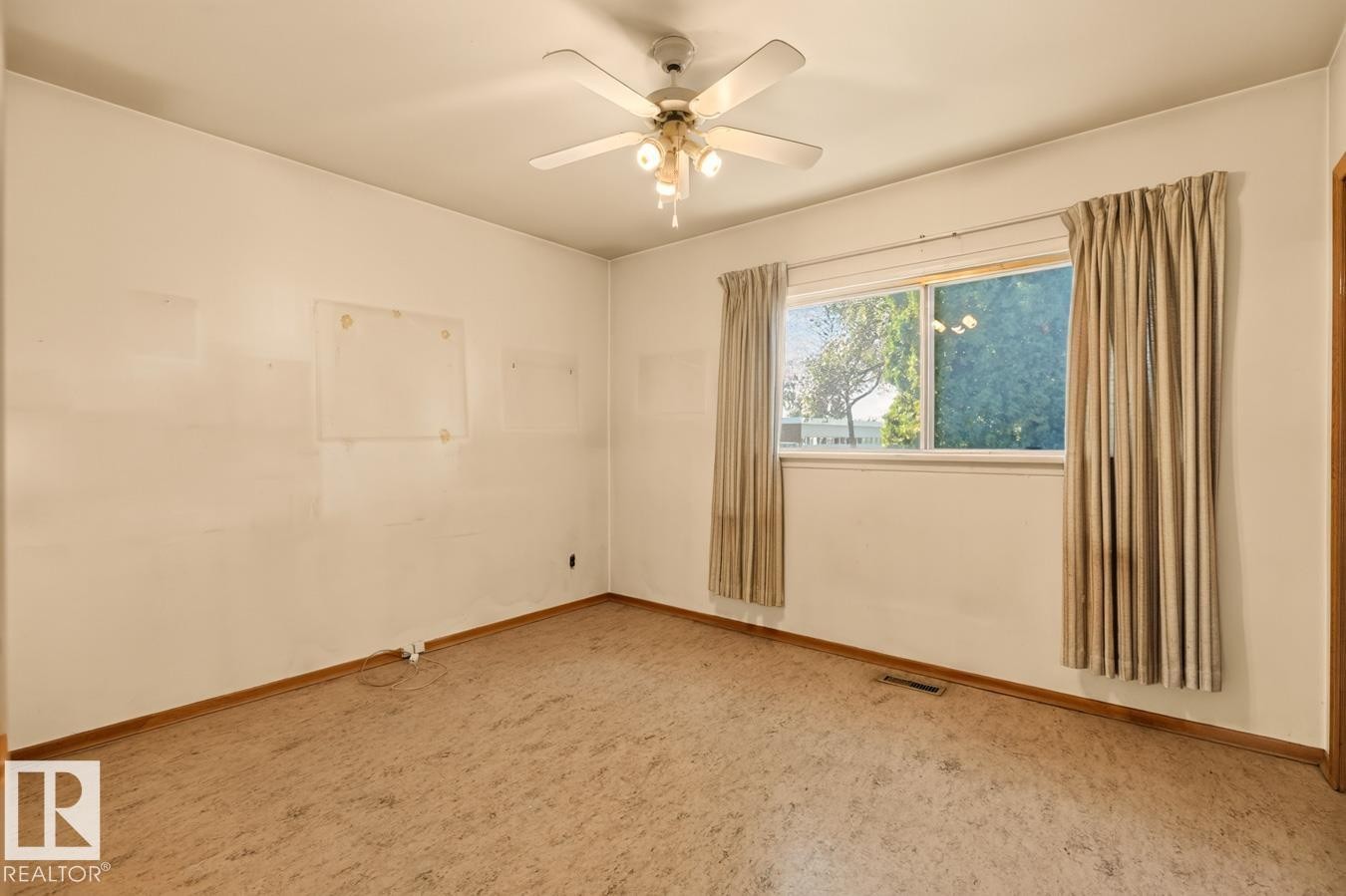 White painted walls, wood-finish baseboards, and a ceiling fan with integrated lighting - 12309 128 Street Nw, Edmonton, AB