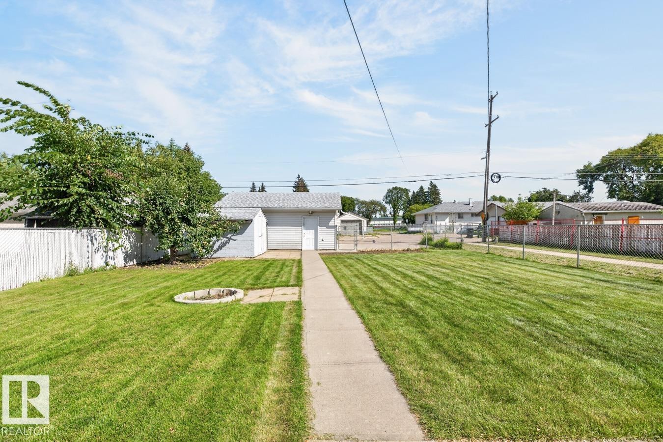 Expansive grassy yard with a concrete pathway leading to a detached garage - 12309 128 Street Nw, Edmonton, AB