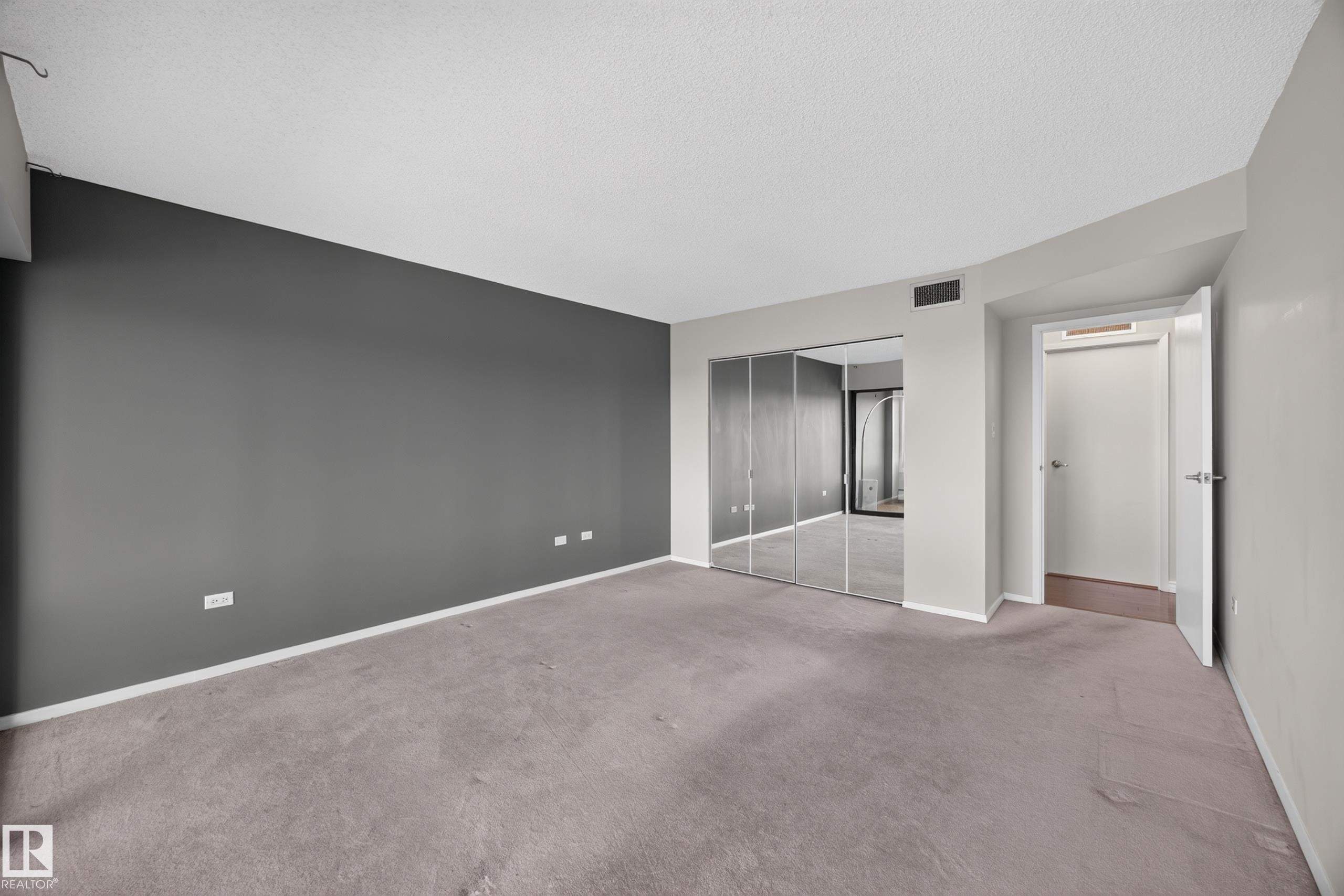 Large bedroom featuring double sliding doors leading to flex space with large south facing windows and stunning views of the River Valley. - #803 10011 123 St Nw, Edmonton, AB