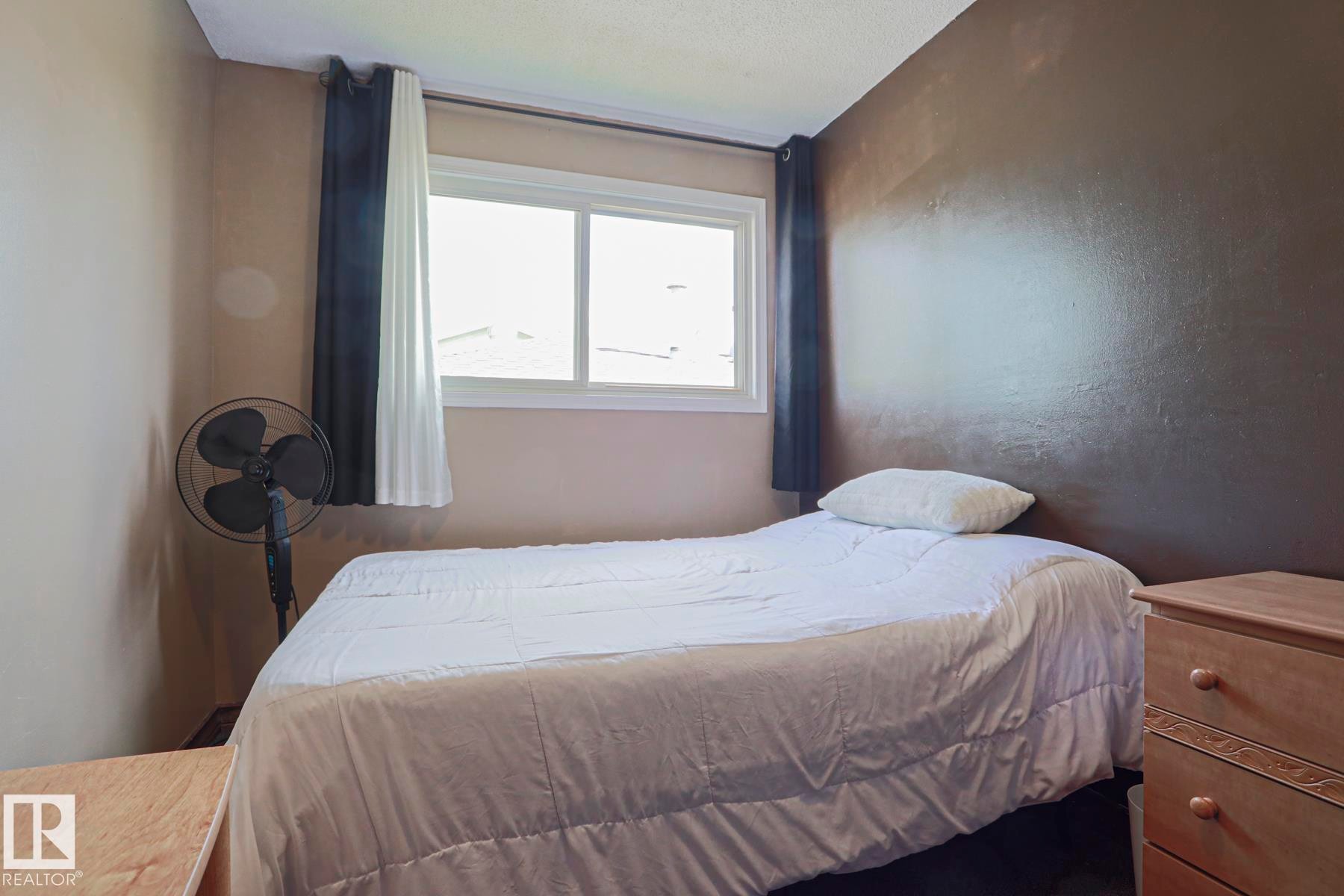 Neutral wall tones with a contrasting accent wall and window with white trim - 11440 144 Avenue Nw, Edmonton, AB