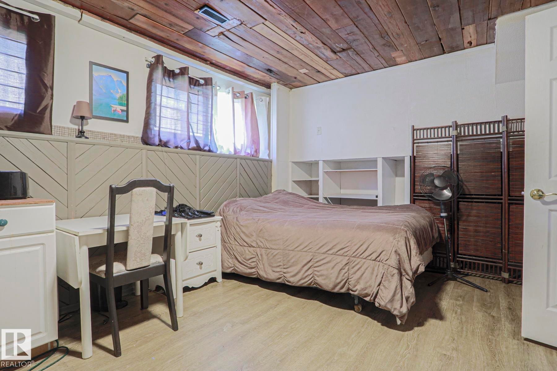 Wood-finish ceiling, light wood-finish flooring, built-in shelving, white paneled wainscoting, and multiple windows - 11440 144 Avenue Nw, Edmonton, AB