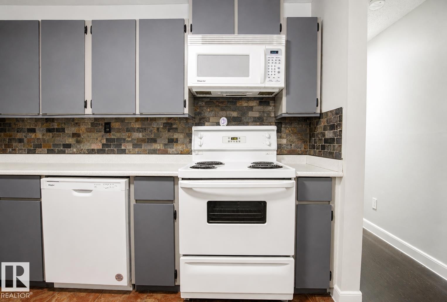 White appliances, subway tile backsplash, white countertops, gray cabinetry, and wood-finish flooring - #203 2624 Mill Woods Rd E Nw, Edmonton, AB