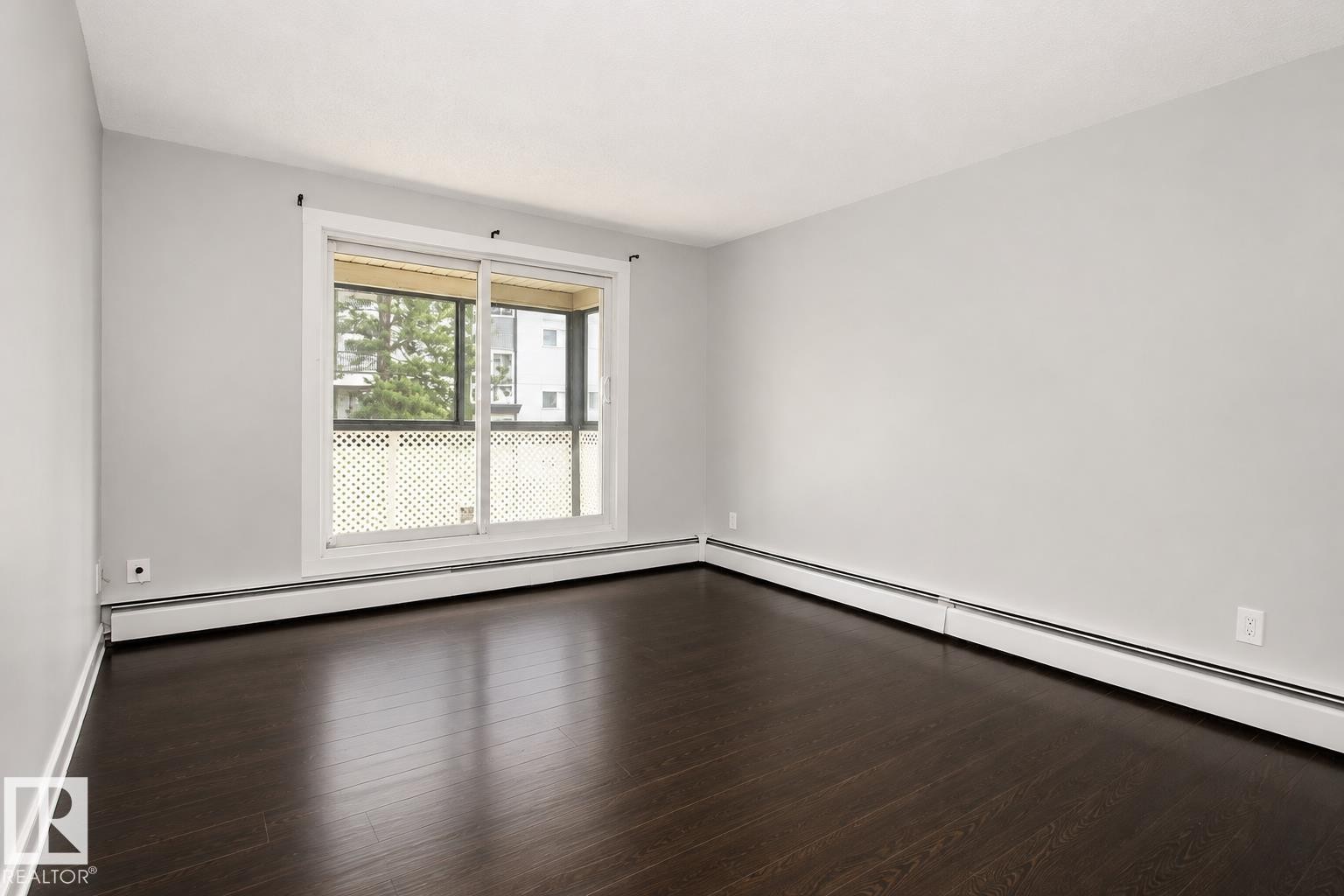 Wood-finish flooring, light grey walls, and a large sliding glass door - #203 2624 Mill Woods Rd E Nw, Edmonton, AB