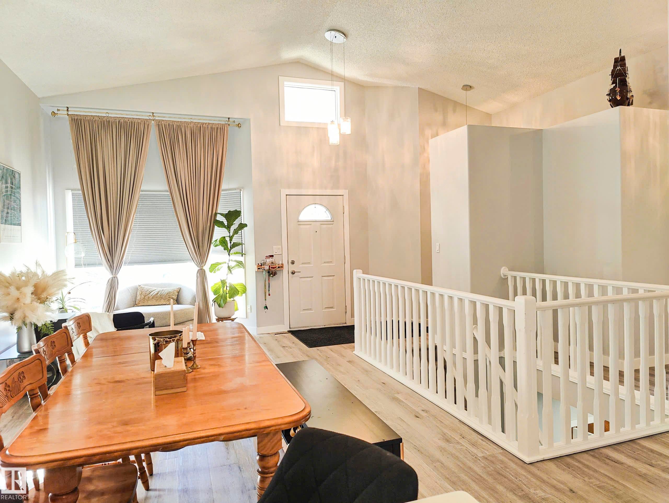 Vaulted ceiling, recessed windows, wood-finish flooring, white door with arched glass insert, white balustrade - 215 Peter Close Nw, Edmonton, AB