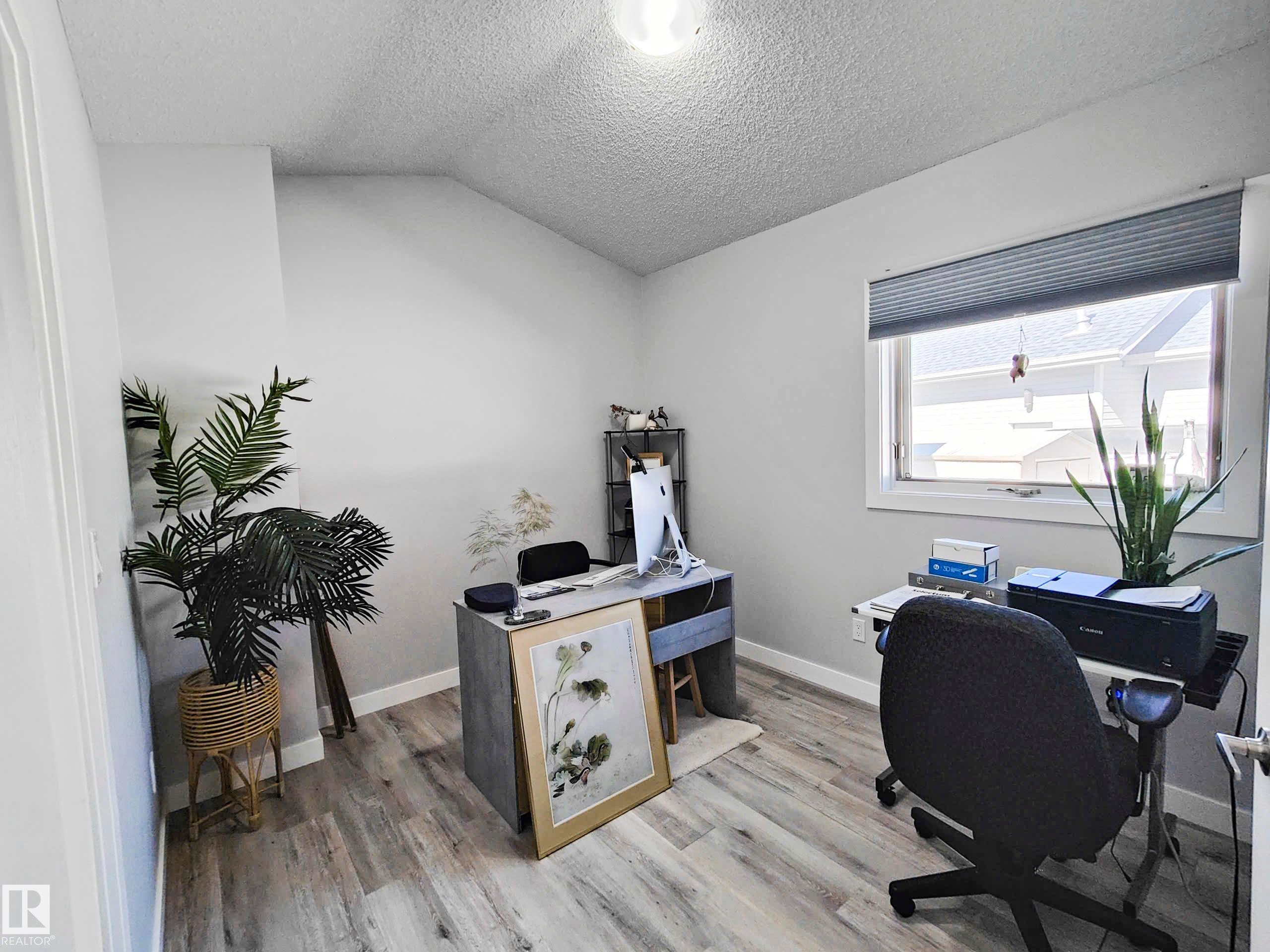 Light-toned wood-finish flooring, a window with horizontal blinds, and a built-in ceiling light fixture - 215 Peter Close Nw, Edmonton, AB