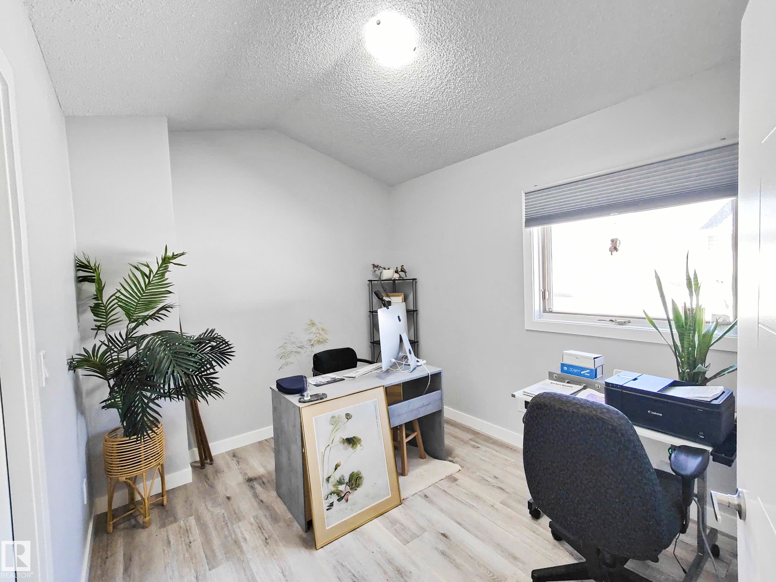 Wood-finish flooring, single window with blind, white trim, and a ceiling-mounted light fixture - 215 Peter Close Nw, Edmonton, AB