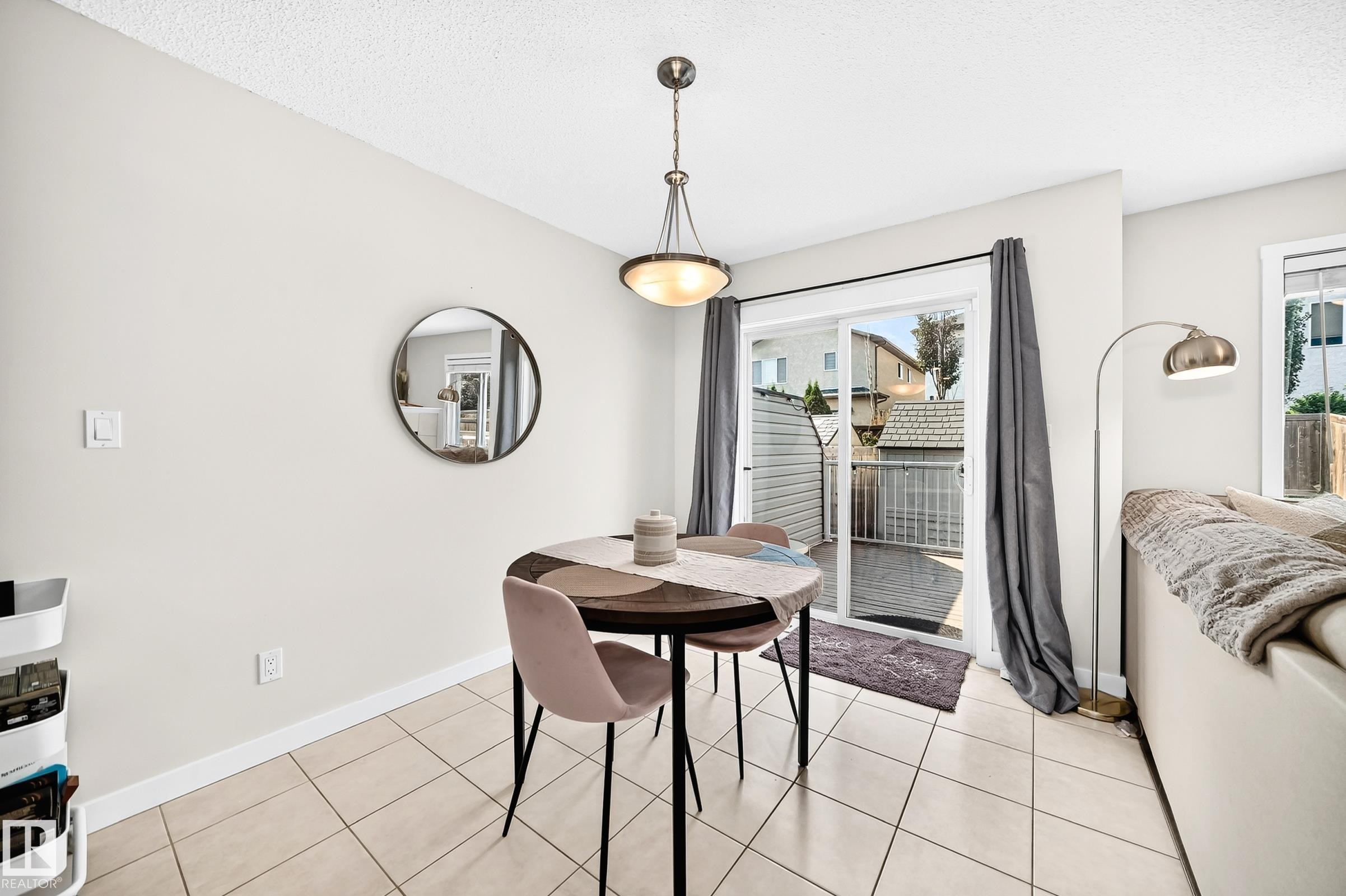 Ceramic tile flooring, sliding glass patio door, and a built-in pendant light fixture - 16832 53 Street Nw, Edmonton, AB