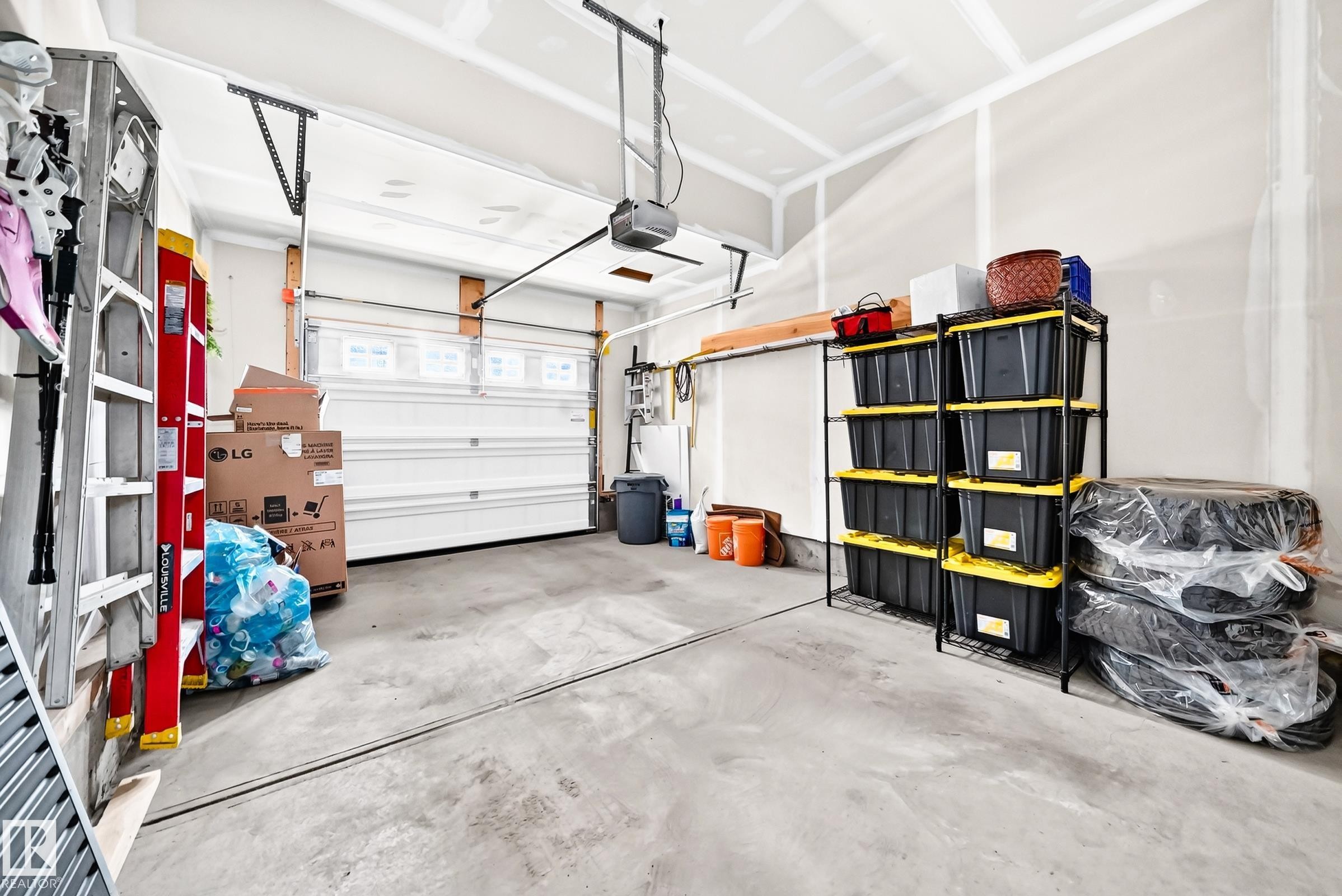 Concrete flooring and a white overhead garage door with upper windows - 16832 53 Street Nw, Edmonton, AB