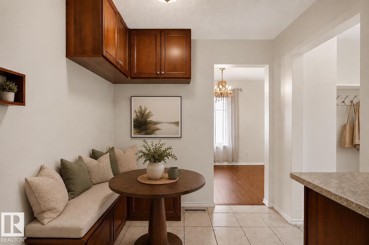 Built-in bench seating with storage, overhead wood cabinetry, tiled flooring, wood-finish flooring in an adjoining room, and a built-in coat rack - 16016 78A Avenue Nw, Edmonton, AB