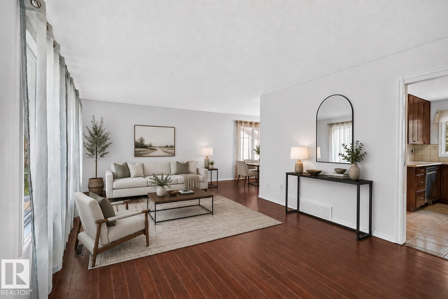 Expansive living space featuring wood-finish flooring, abundant natural light from large windows, and a neutral color palette - 16016 78A Avenue Nw, Edmonton, AB